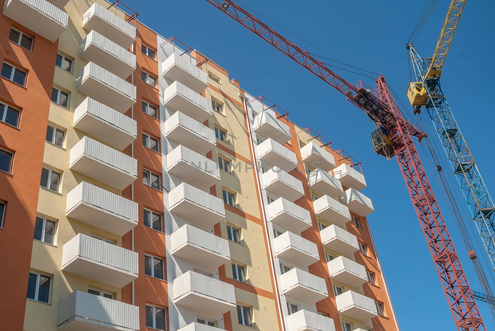 kind of a new multistorey brick residential building with balconies on a sunny day