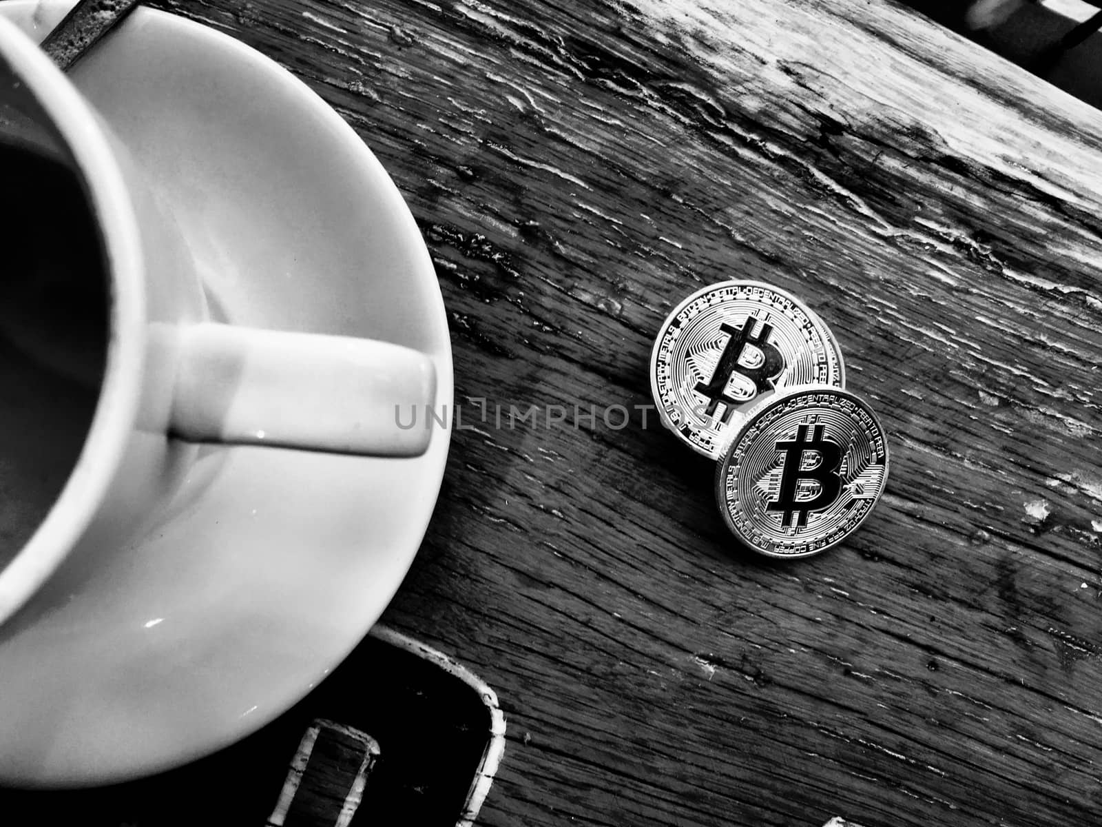 Digital currency physical silver bitcoin coin on table near coffee.