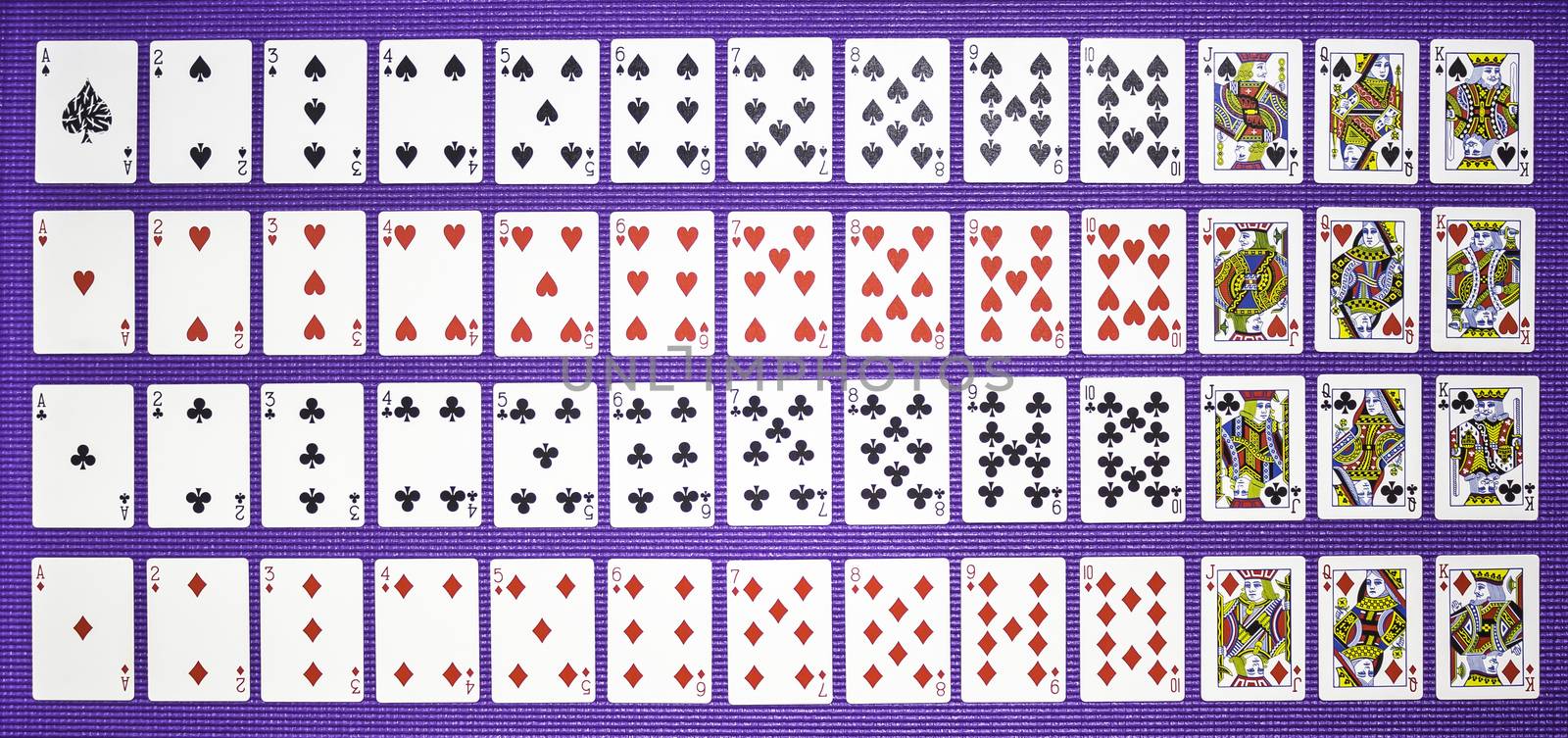 Closeup rows of playing cards on violet background