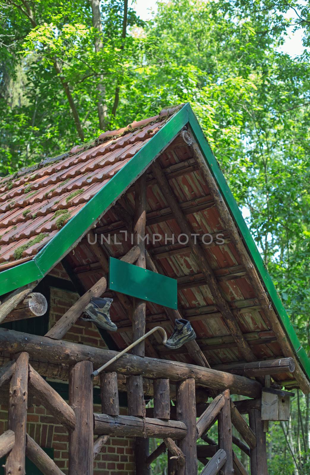 A wooden cabin with walking boots and walking stick in a forest