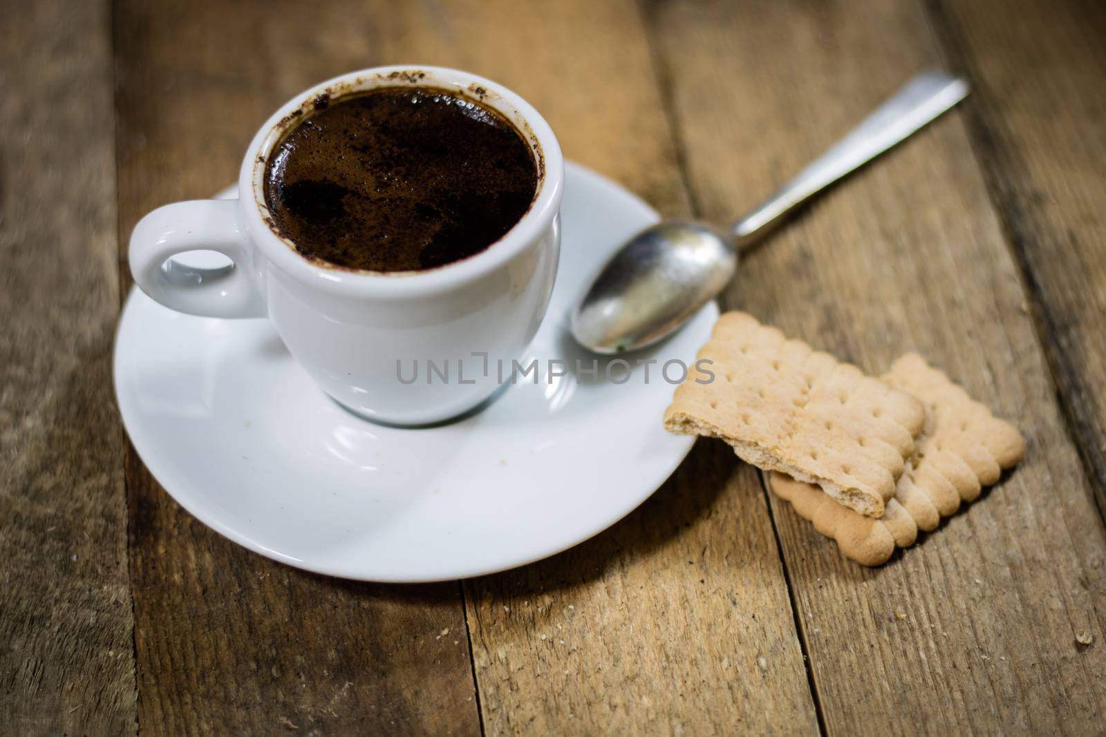 Freshly brewed coffee in mugs on a wooden table with a mill on a black background