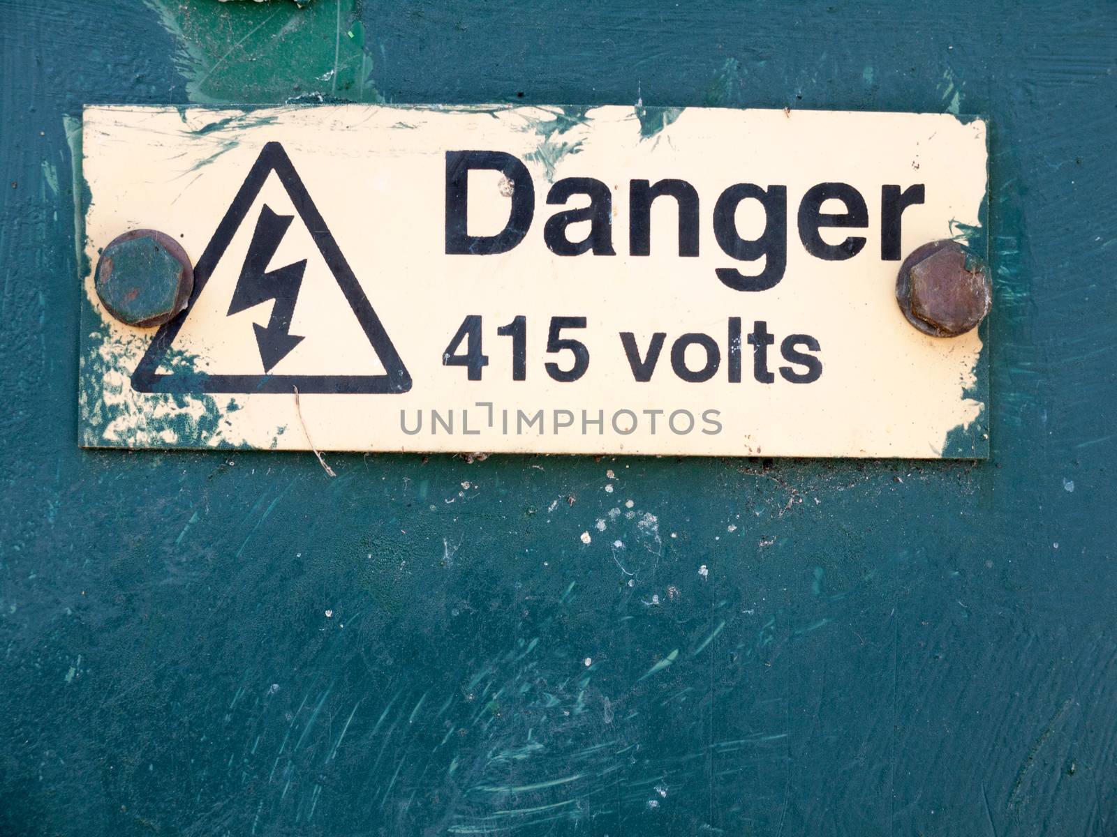 yellow rusted nailed sign on metal box yellow with danger arrow