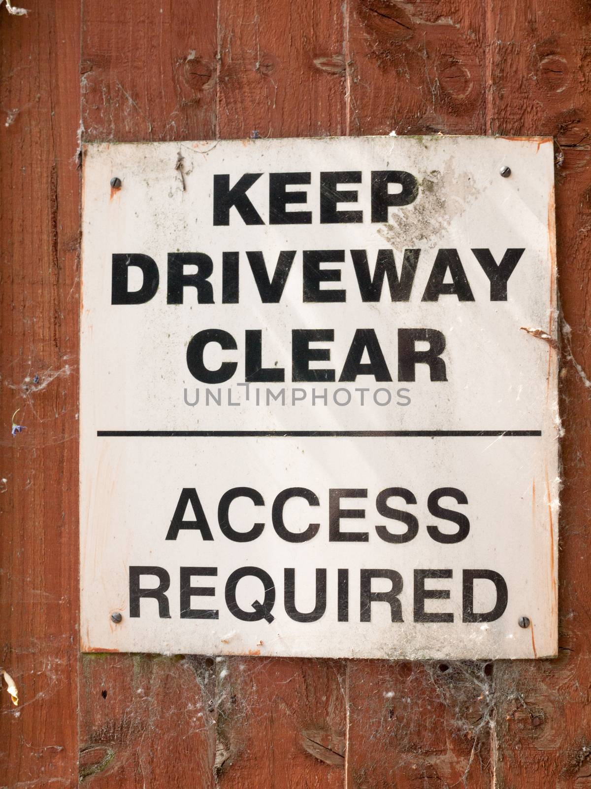 keep driveway clear access required parking sign on wooden shed garden wall
