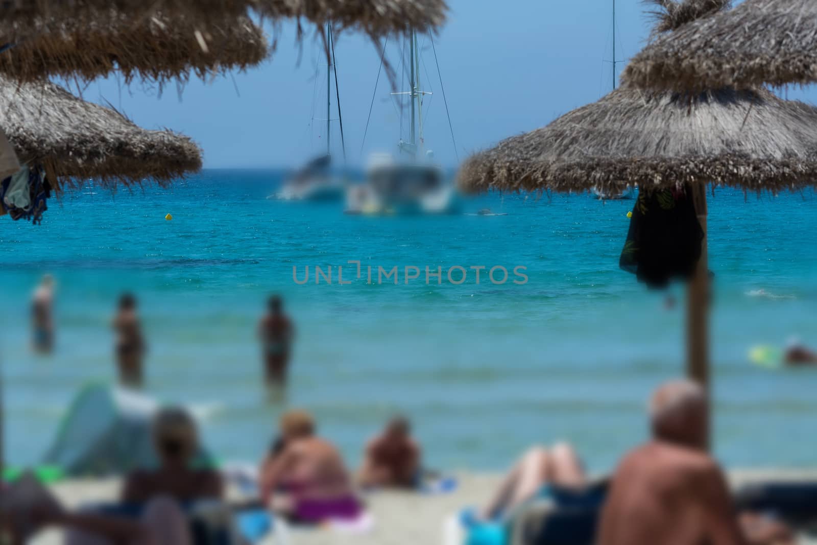Beach life, holidaymaker at the beach bottom part of the image desired blur. Focus above composition overlooking the sea.