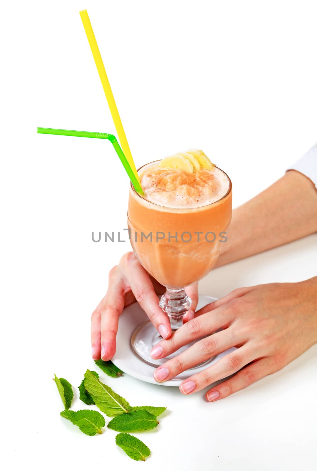Closeup shot of banana smoothie in a big glass cup with two straws in woman's hands. Isolated on white background. Lady with a drink
