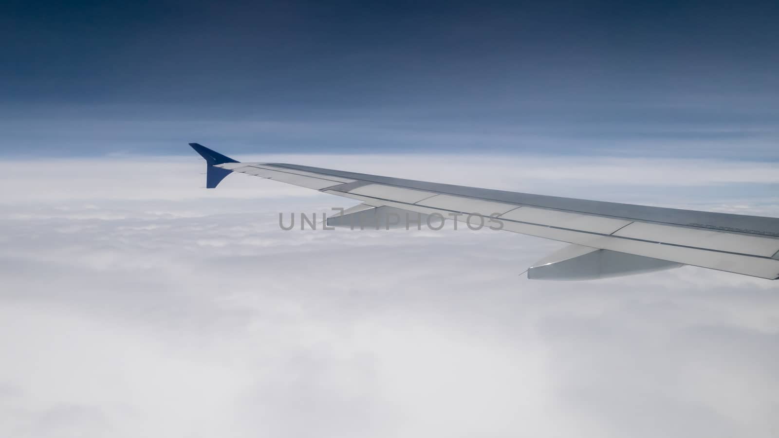 The airplane wing on the beautiful cloudy and sky.