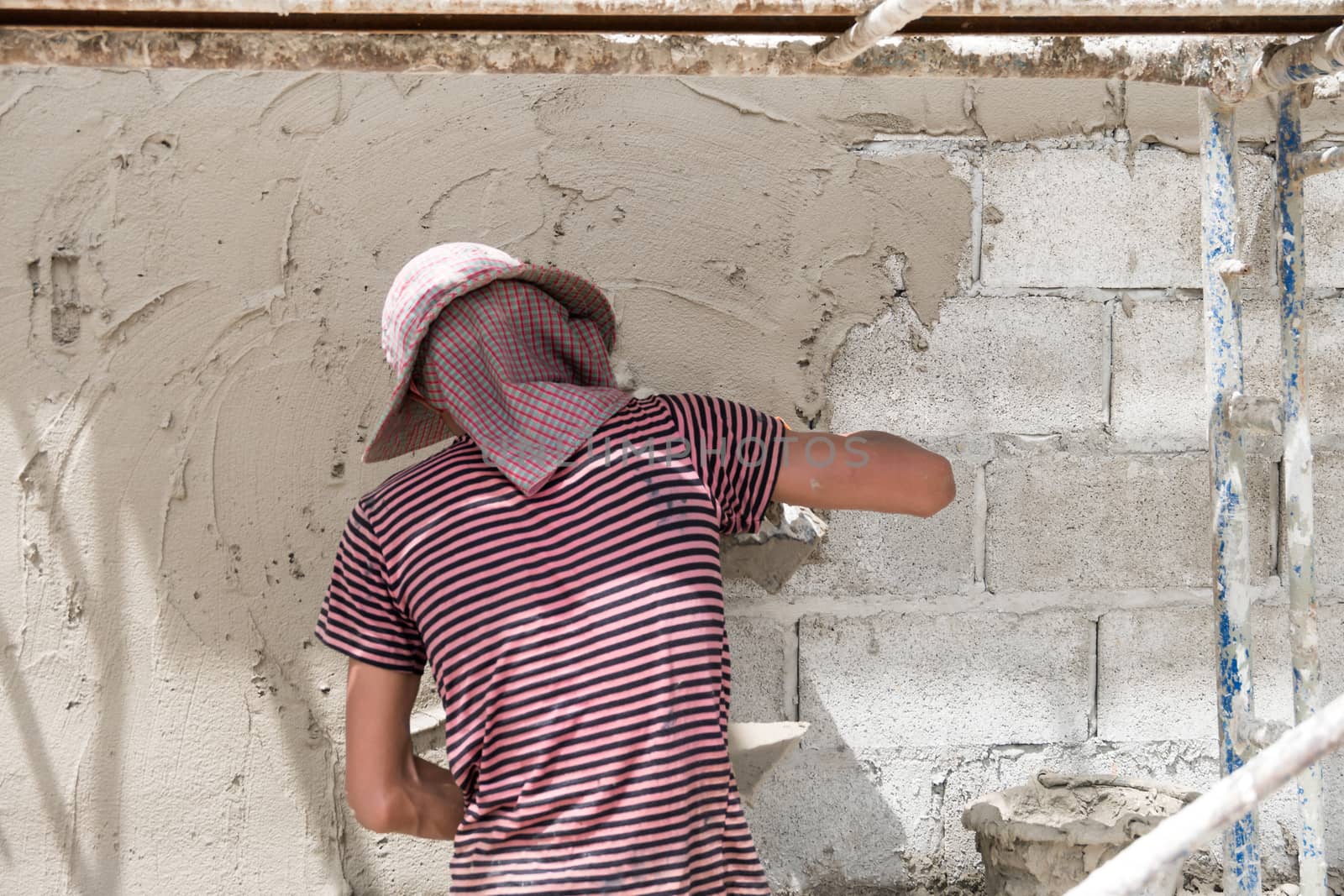 Close up of industrial bricklayer installing cement on construction site