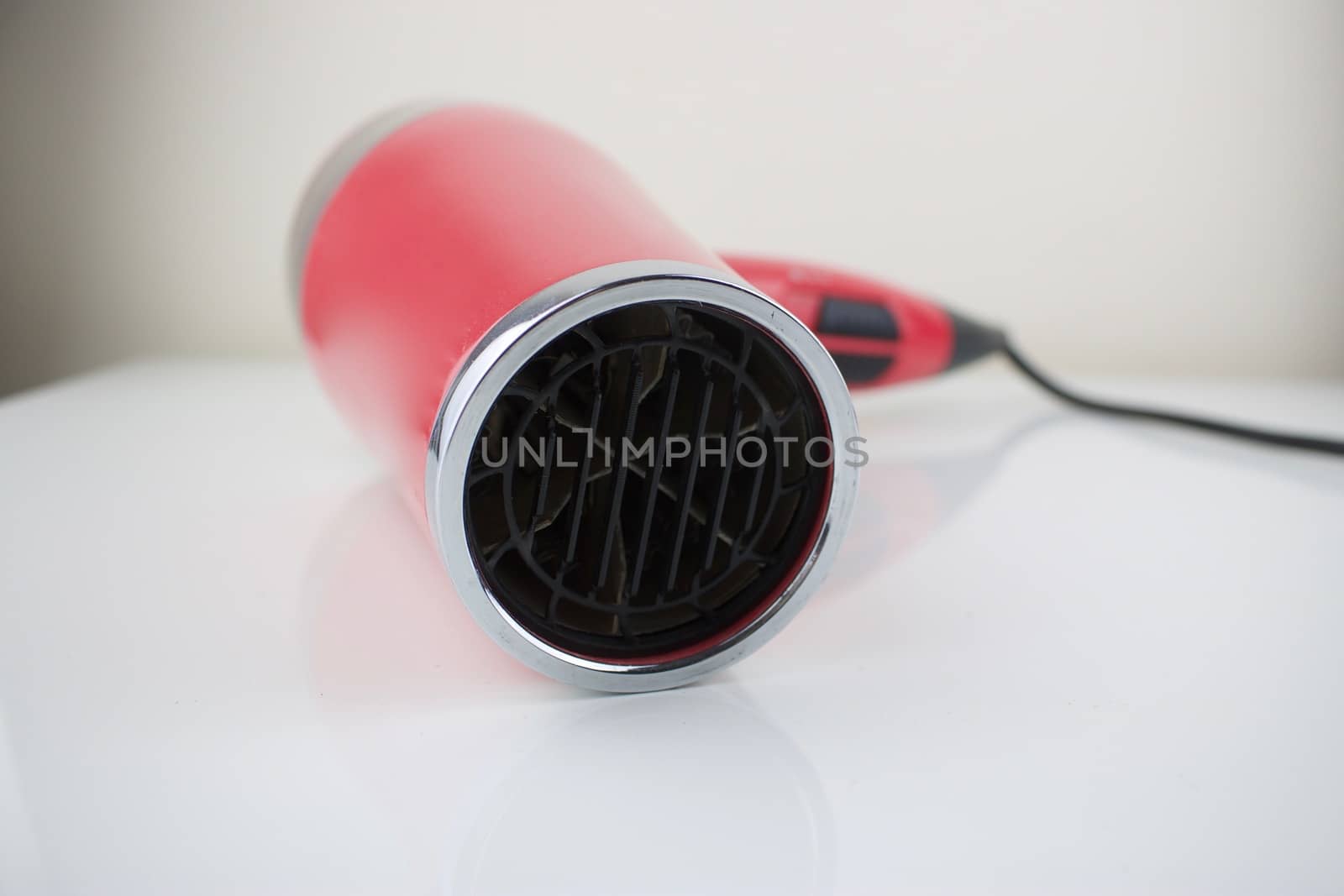 Pink hair dryer on the white table. Hair salon concept.
