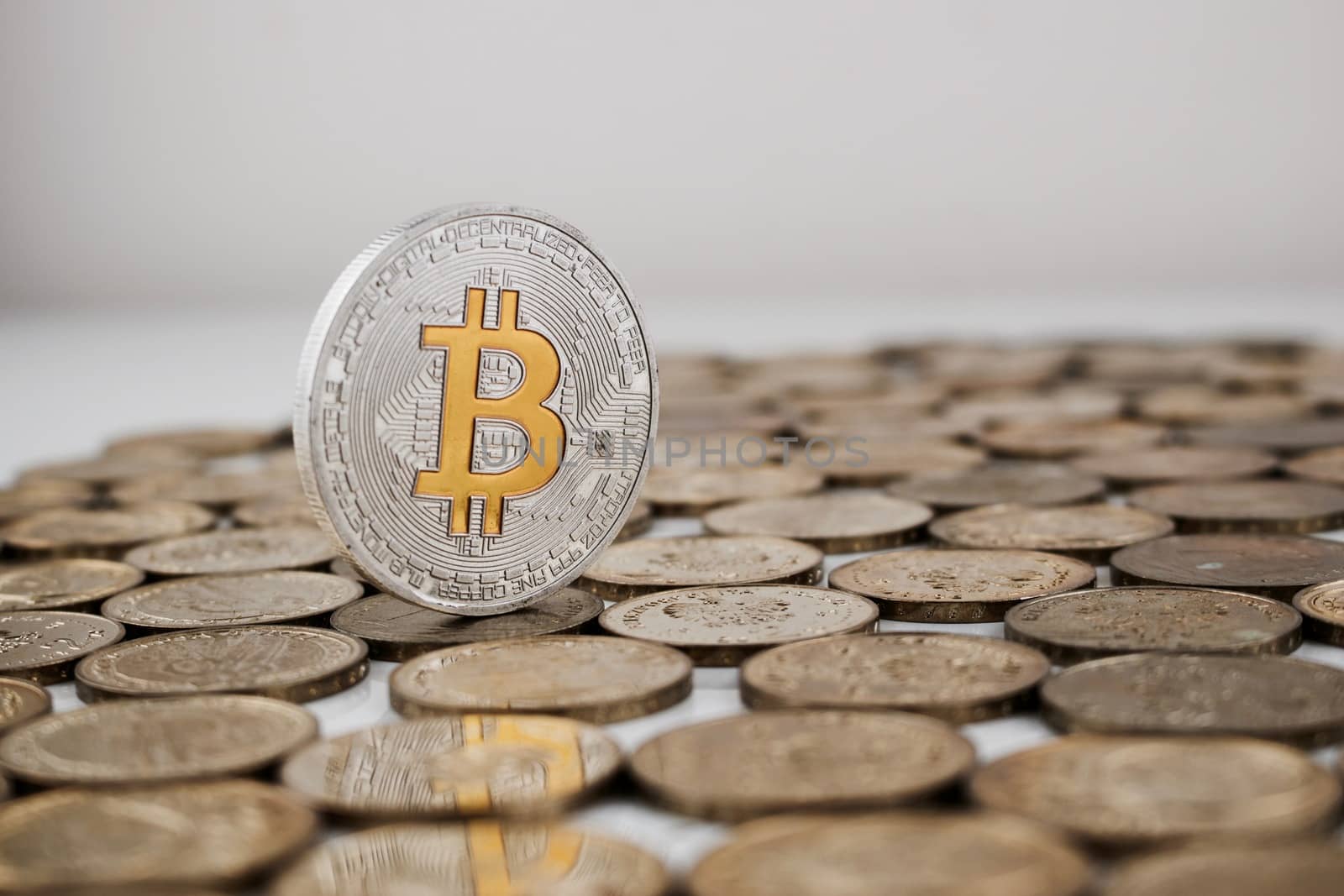 Cryptocurrency physical silver bitcoin coin with yellow currency sign.