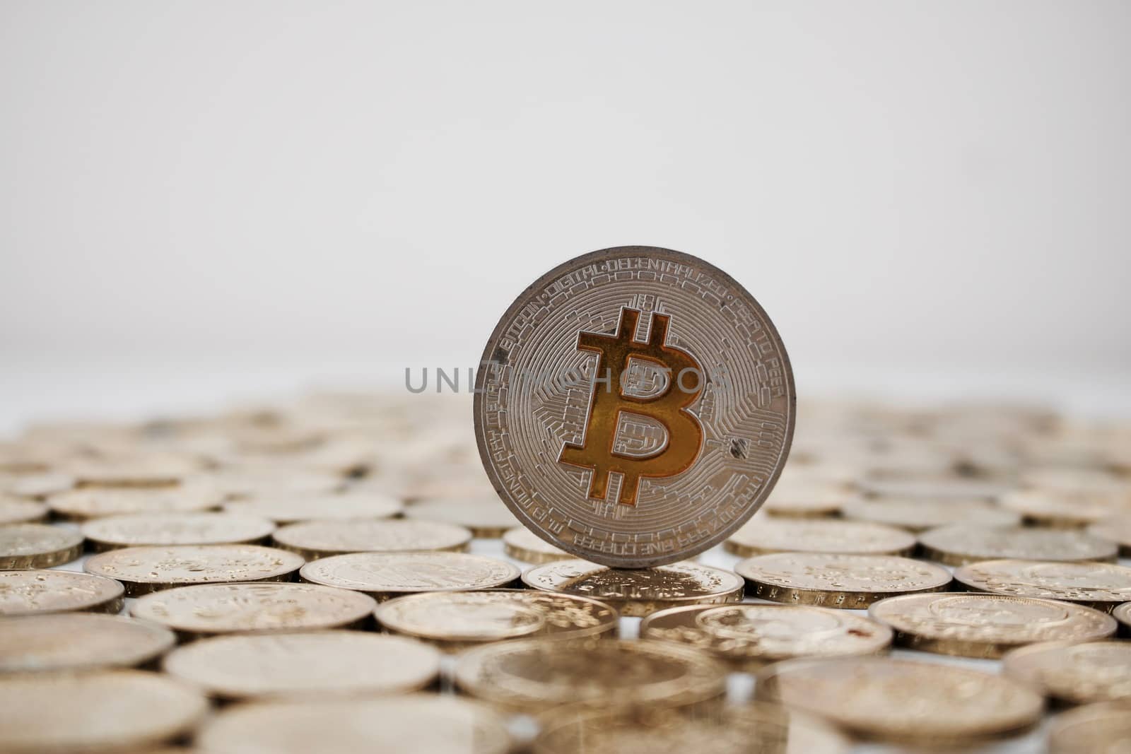 Digital currency physical silver bitcoin coin with yellow sign.