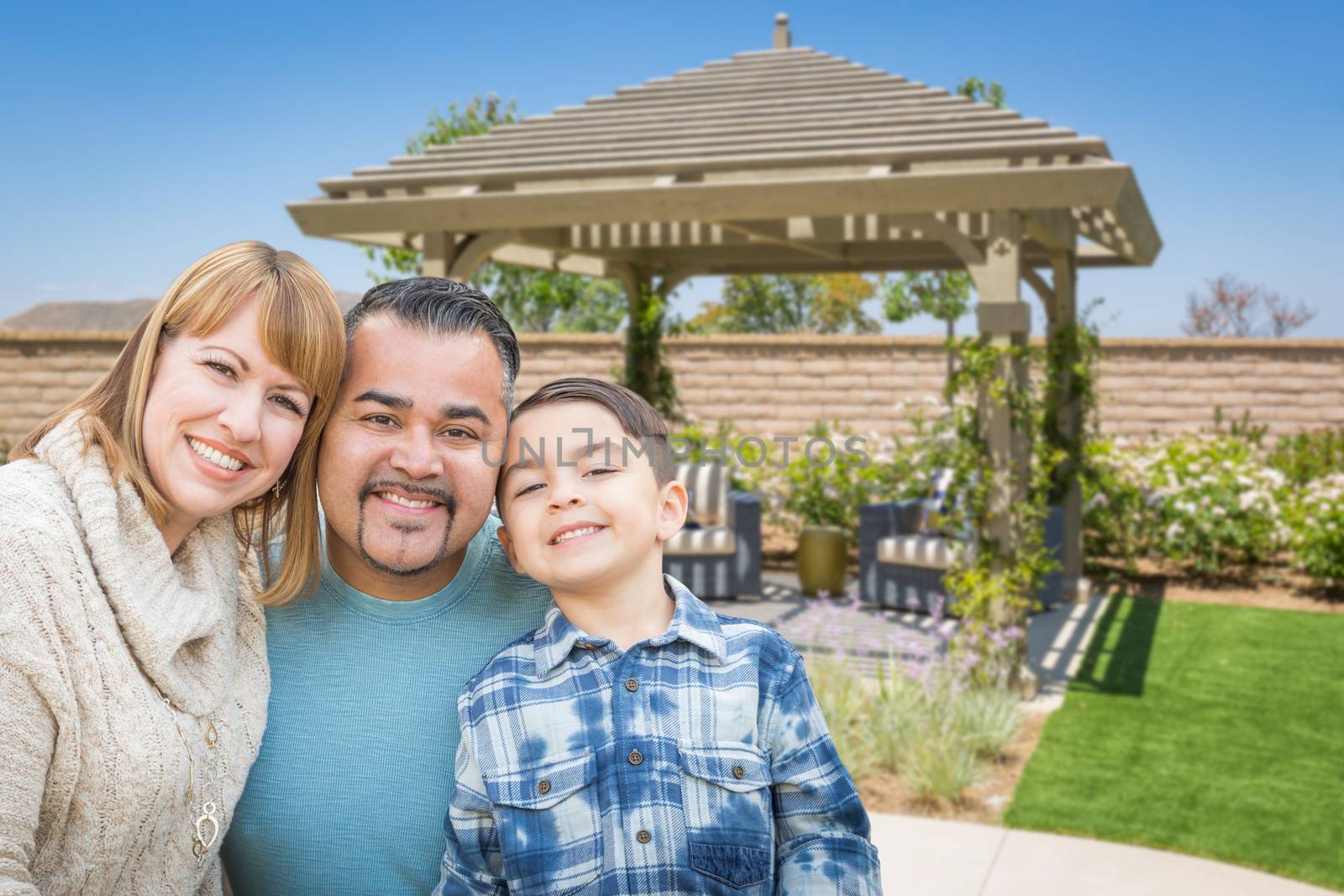 Mixed Race Family In Back Yard Near Patio Cover. by Feverpitched