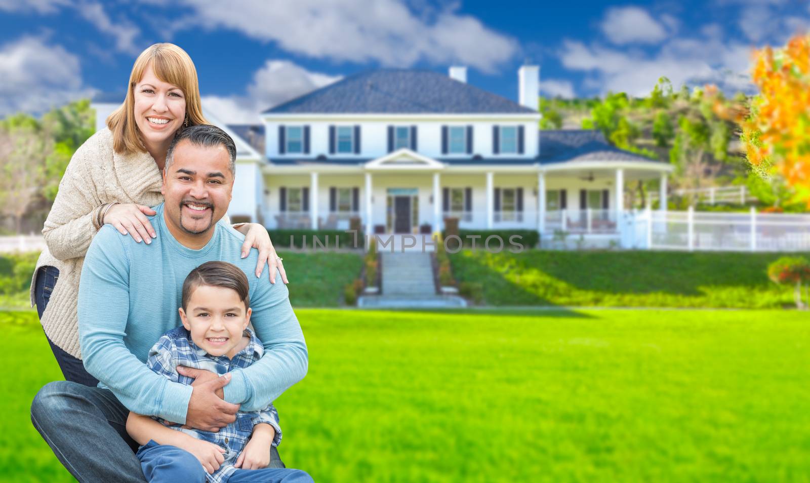 Mixed Race Family In Front Yard of Beautiful House and Property. by Feverpitched