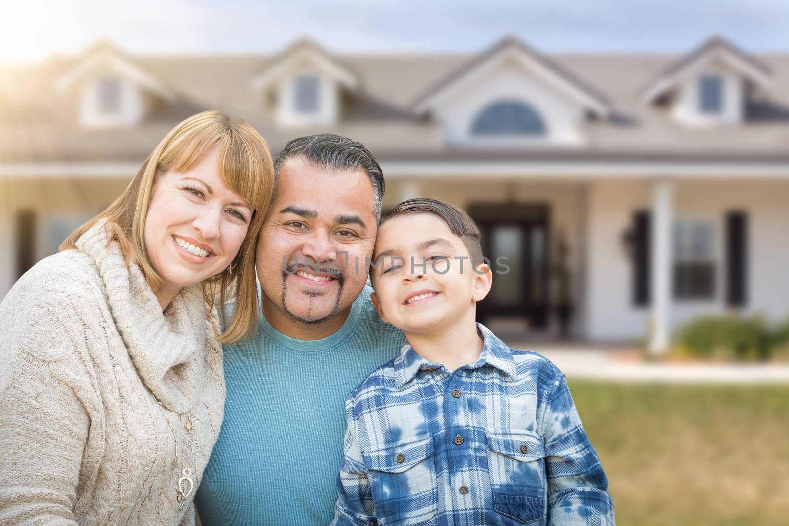 Mixed Race Family In Front Yard of Beautiful House and Property. by Feverpitched