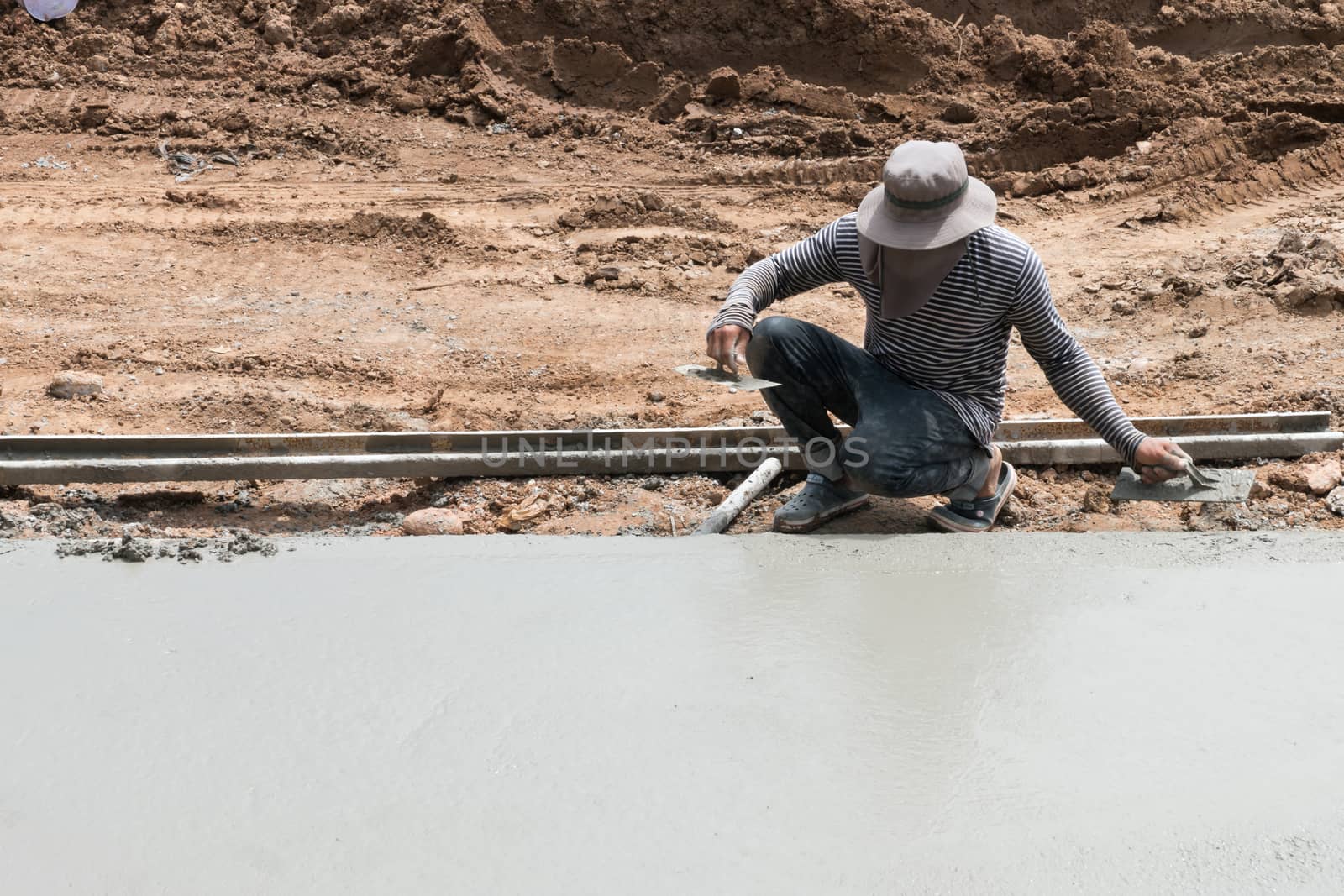 Close up of industrial bricklayer installing cement on construction site