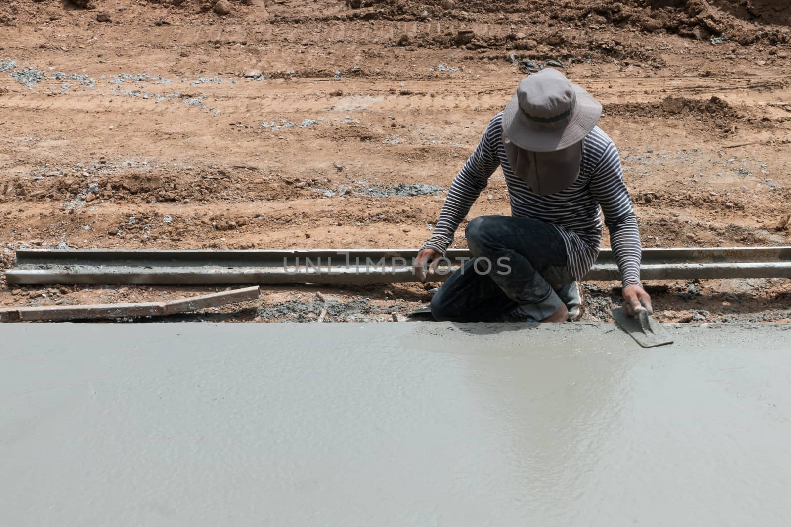 Close up of industrial bricklayer installing cement on construction site