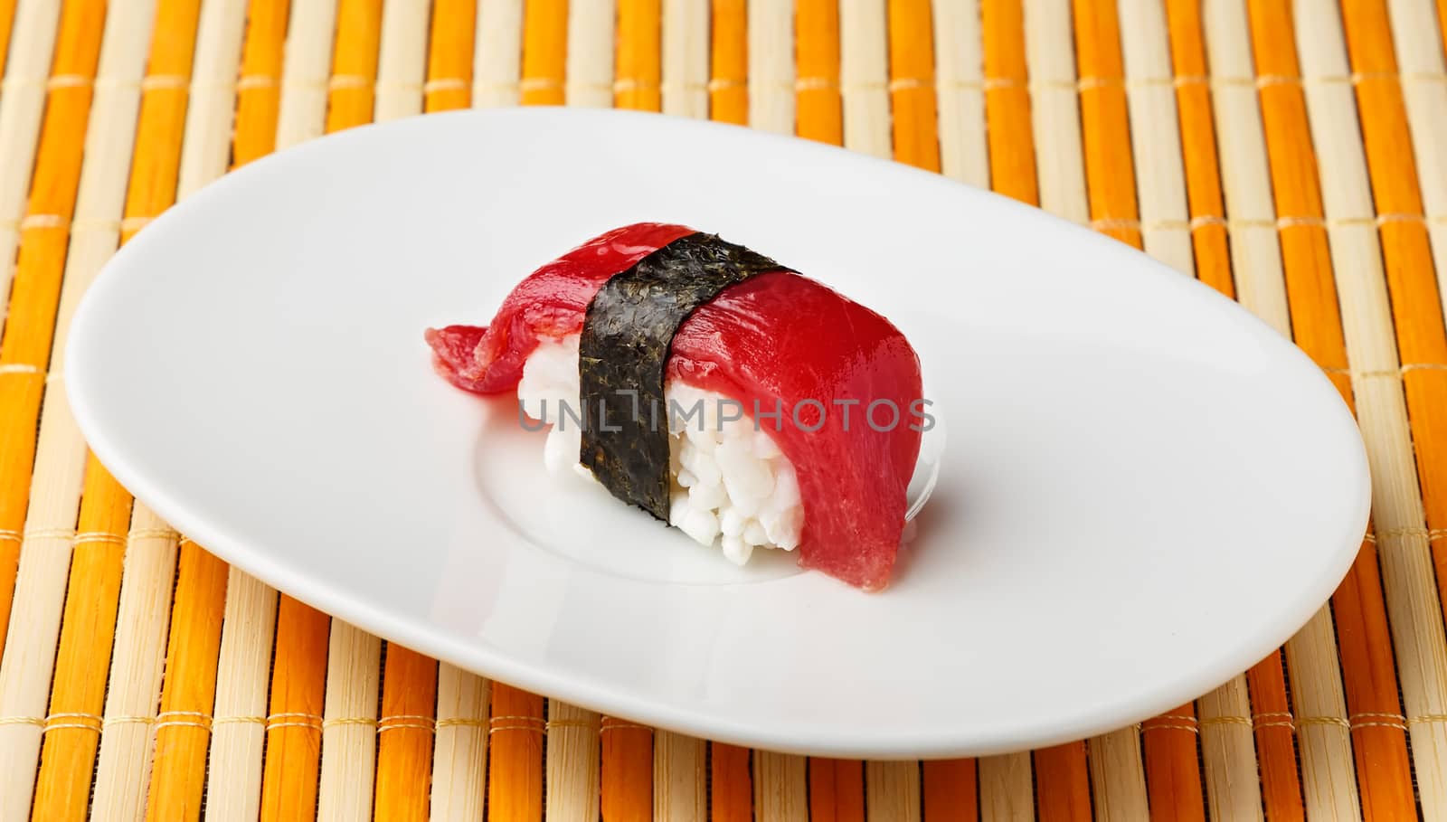  Red tuna Nigiri with Nori seaweed on white plate.Raw fish in traditional Japanese sushi style. Horizontal image.