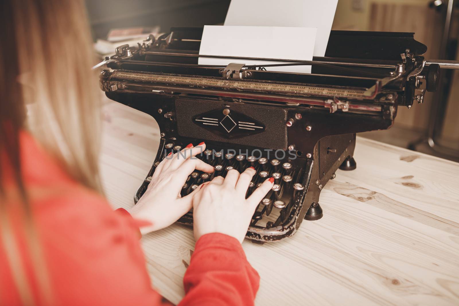 Secretary at old typewriter with telephone. Young woman using ty by natazhekova