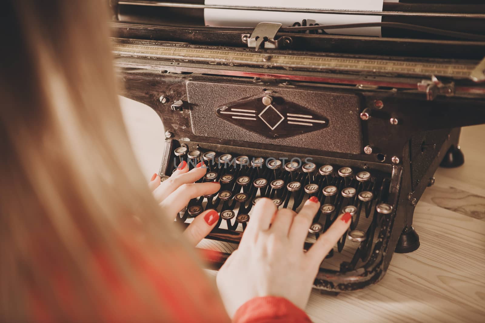 Secretary at old typewriter with telephone. Young woman using typewriter. Business concepts. Retro picture style.