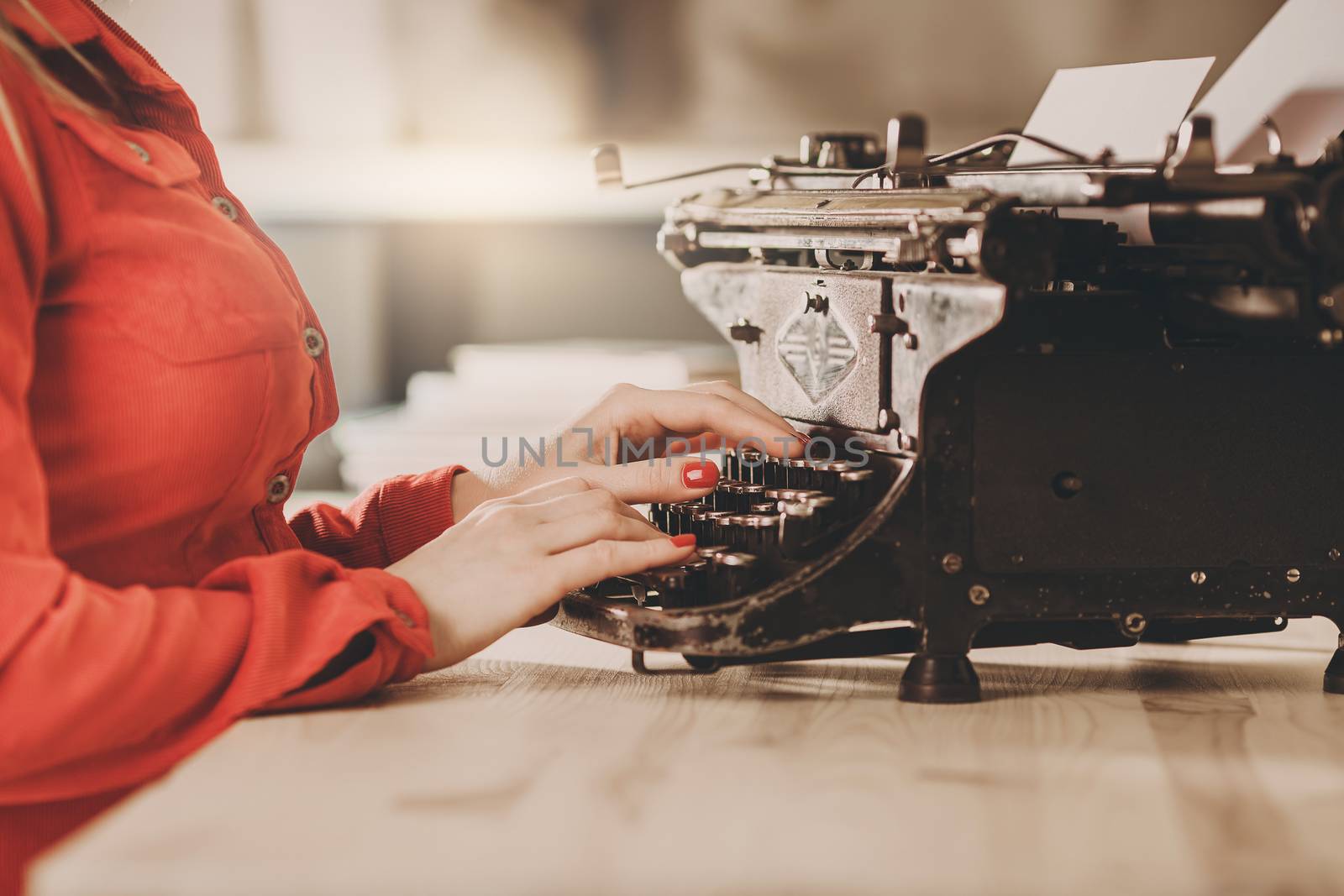 Secretary at old typewriter with telephone. Young woman using typewriter. Business concepts. Retro picture style.