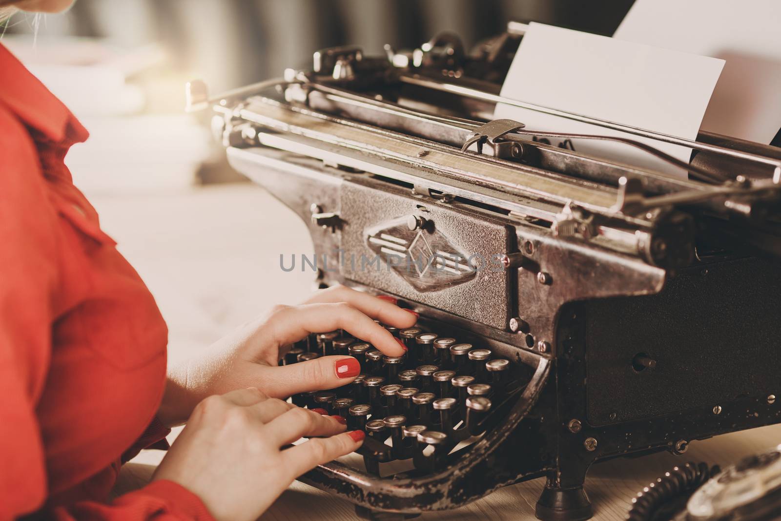 Secretary at old typewriter with telephone. Young woman using typewriter. Business concepts. Retro picture style.