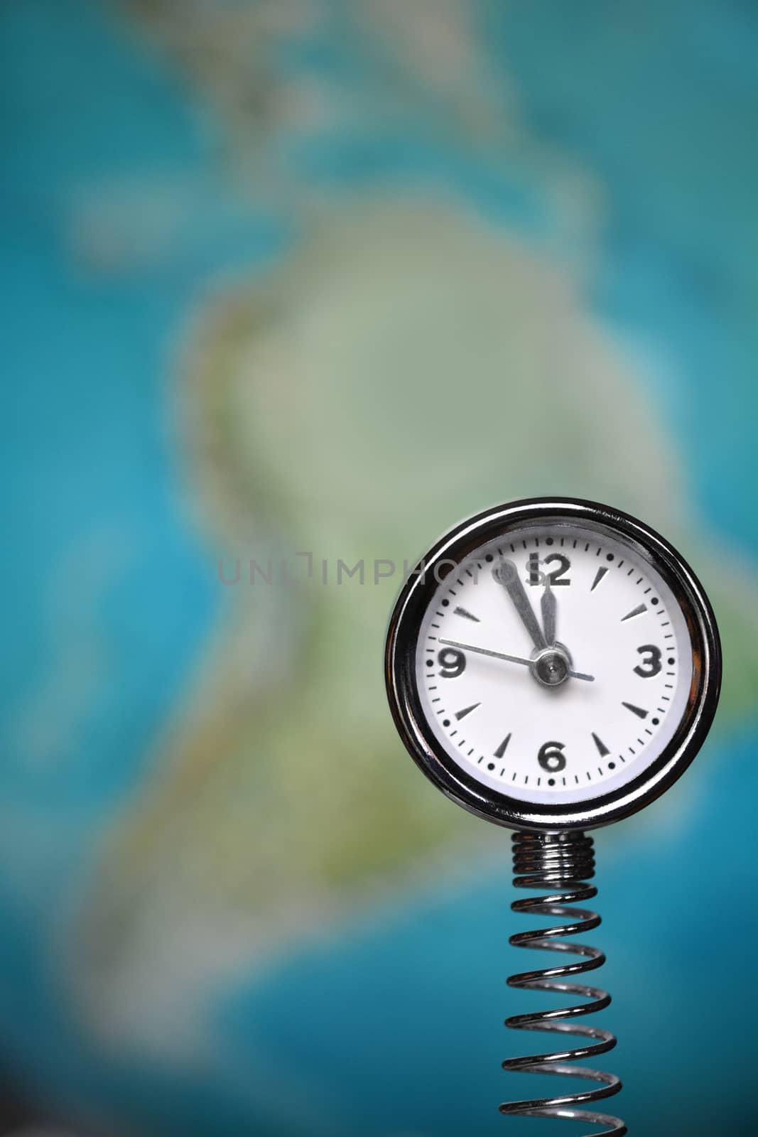Clock showing 11:56 in front of blurred globe