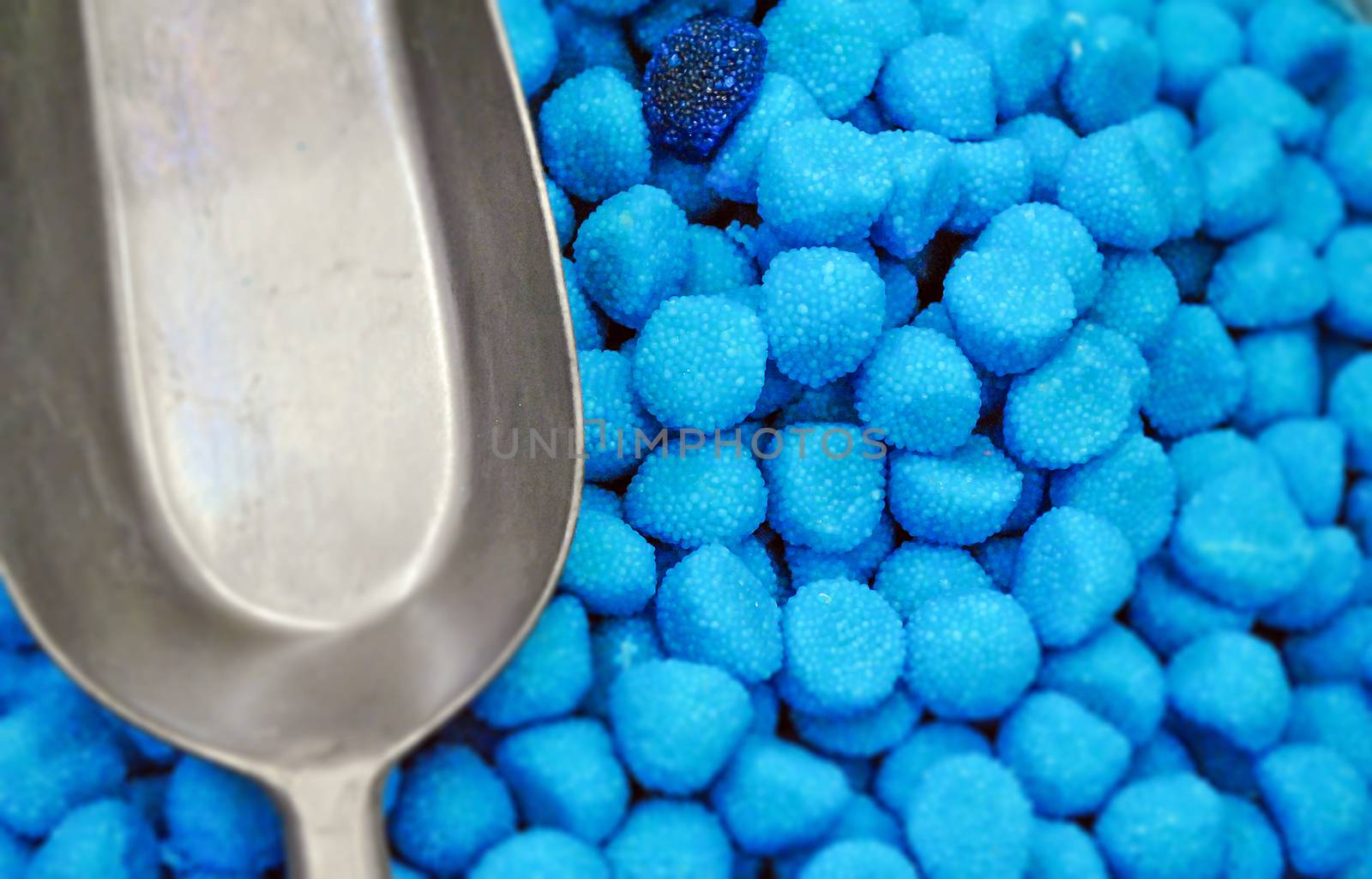 aerial view of blue sugar candies with a metallic shovel