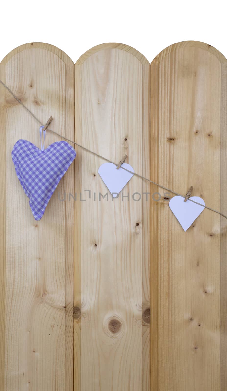 Three hearts with clothes pegs on a cord on wood