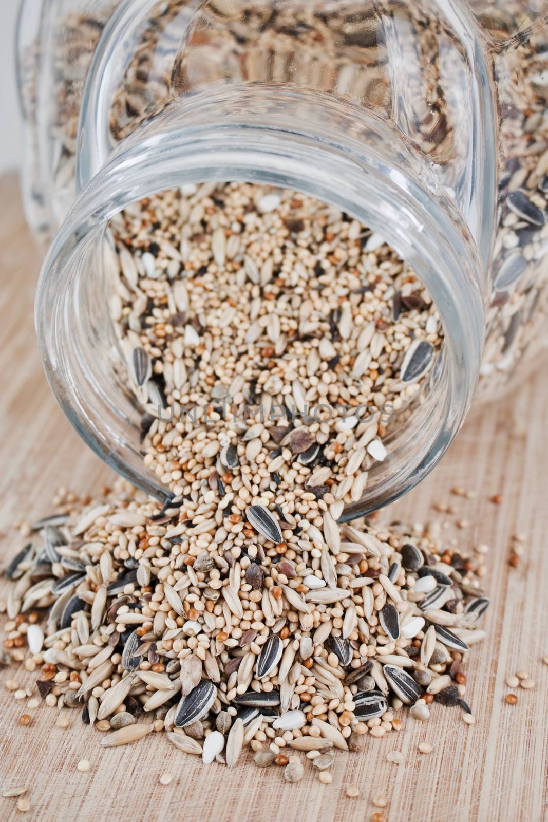 Small seeds in glass jar on the wooden board in the kitchen.