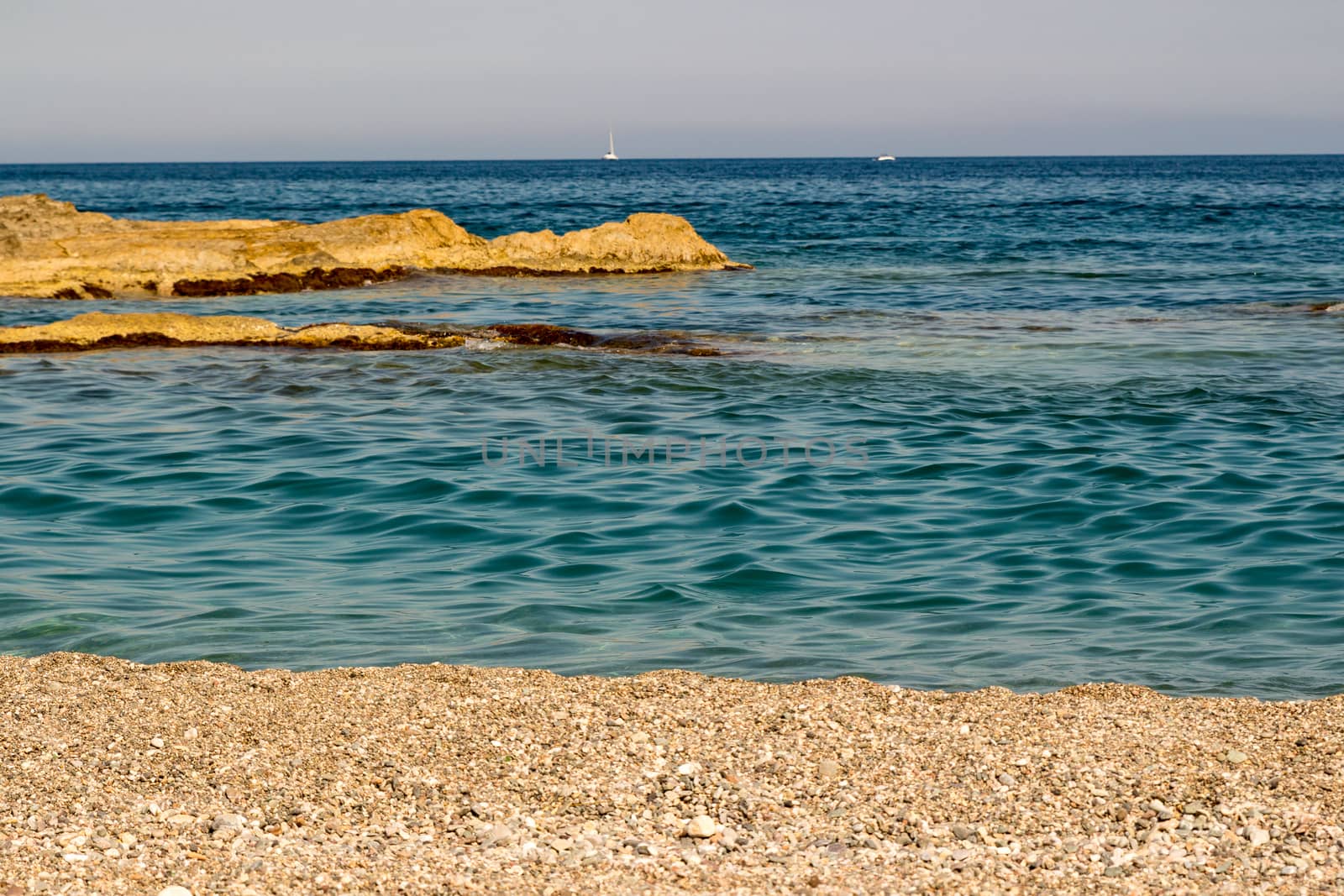 Sand the rocks and a blue Mediterranean sea