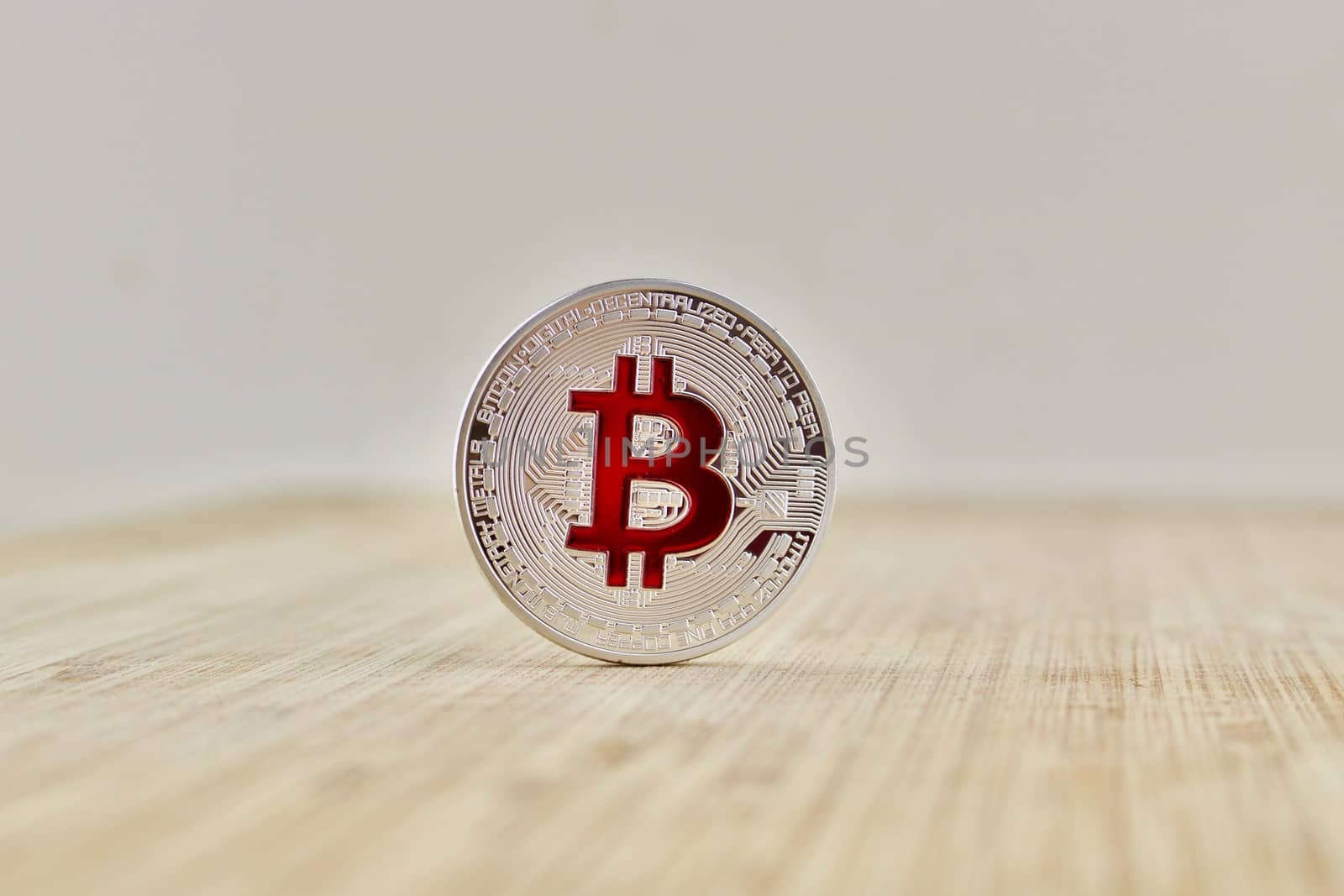 Cryptocurrency physical silver bitcoin coin with red sign on the wooden board.