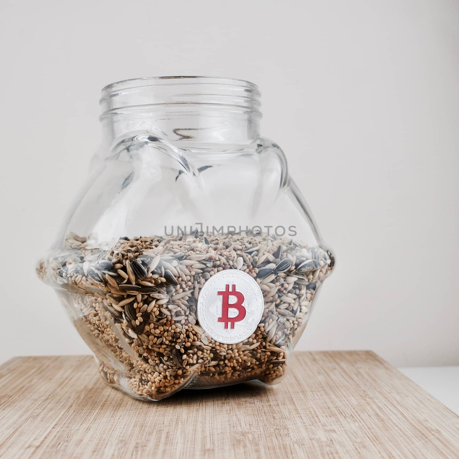 Digital currency physical silver bitcoin coin in glass jar with seeds.