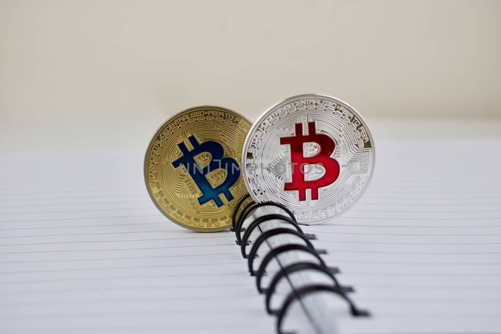 Digital currency physical gold and silver bitcoins in notebook on the table.