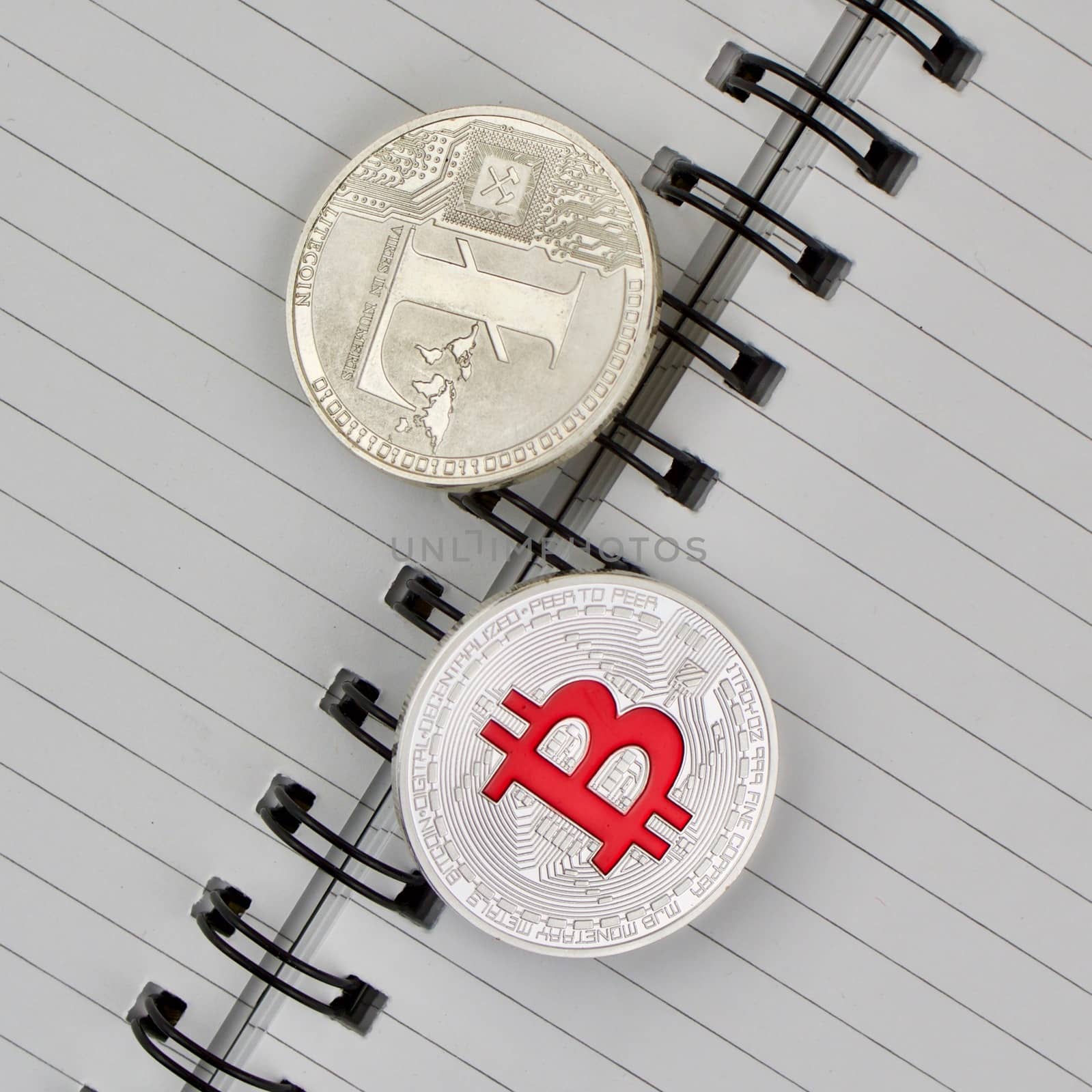 Digital currency physical silver Litecoin and Red Bitcoin coin.