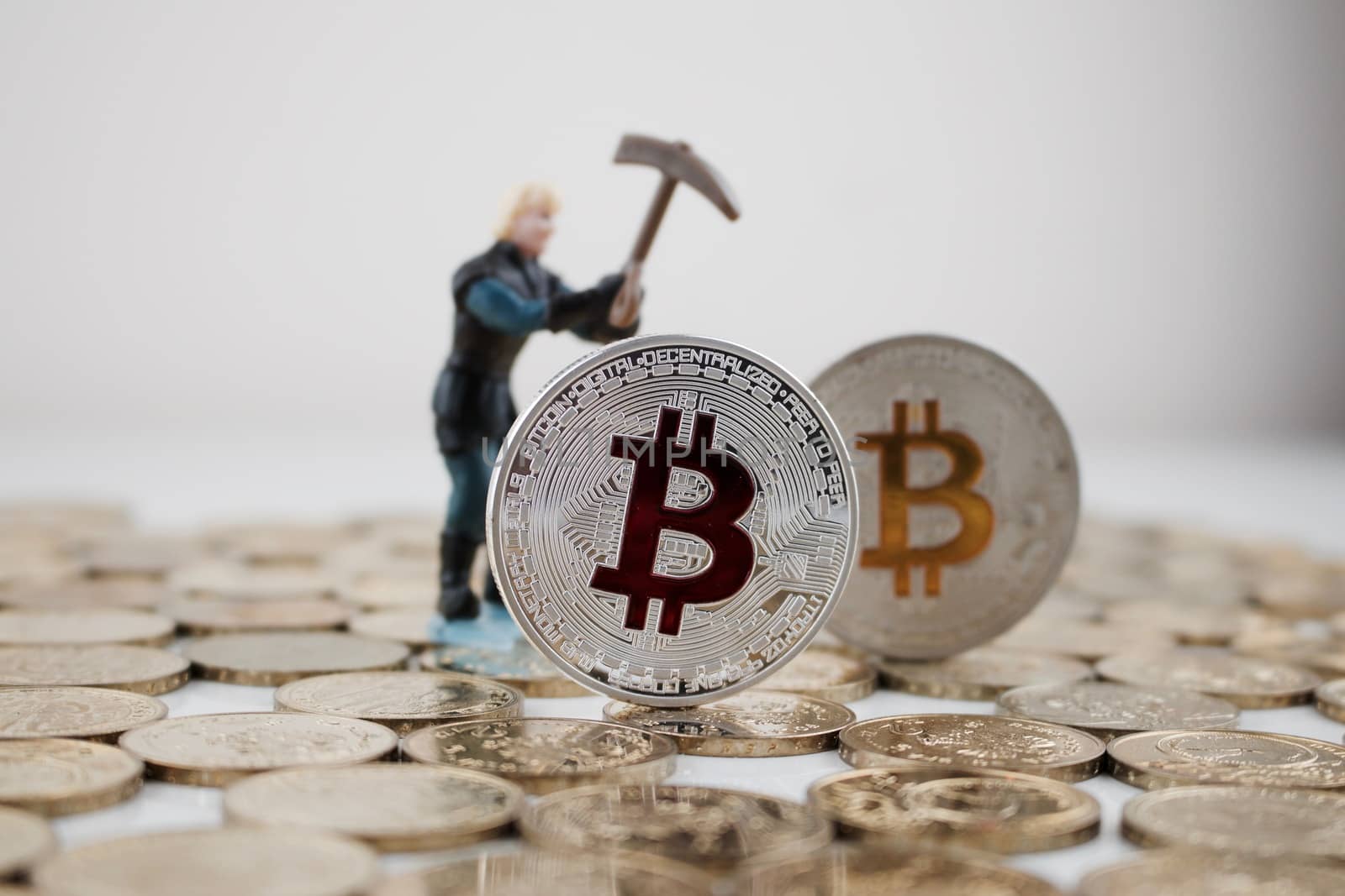Digital currency physical silver bitcoin coin with red and yellow sign.