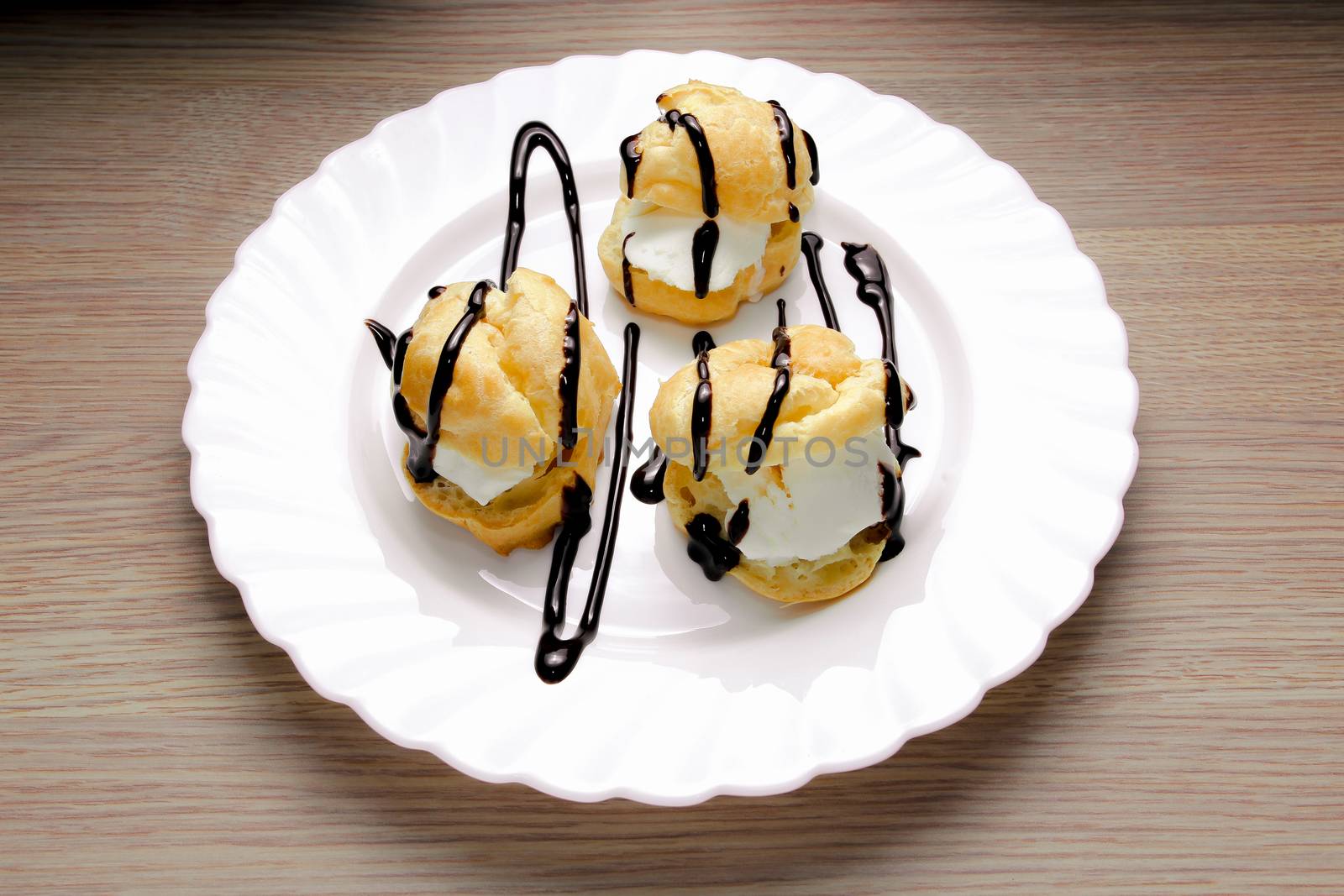 Profiteroles with ice cream. On a wooden background