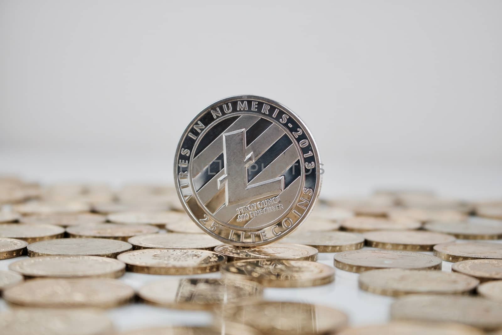 Digital currency physical silver Litecoin coin on gold coins.