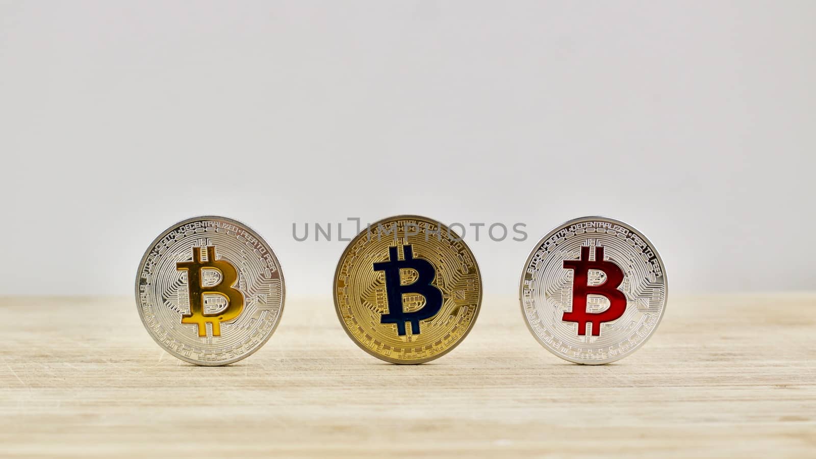 Bitcoins. Physical cryptocurrency gold and silver coins on the wooden board.