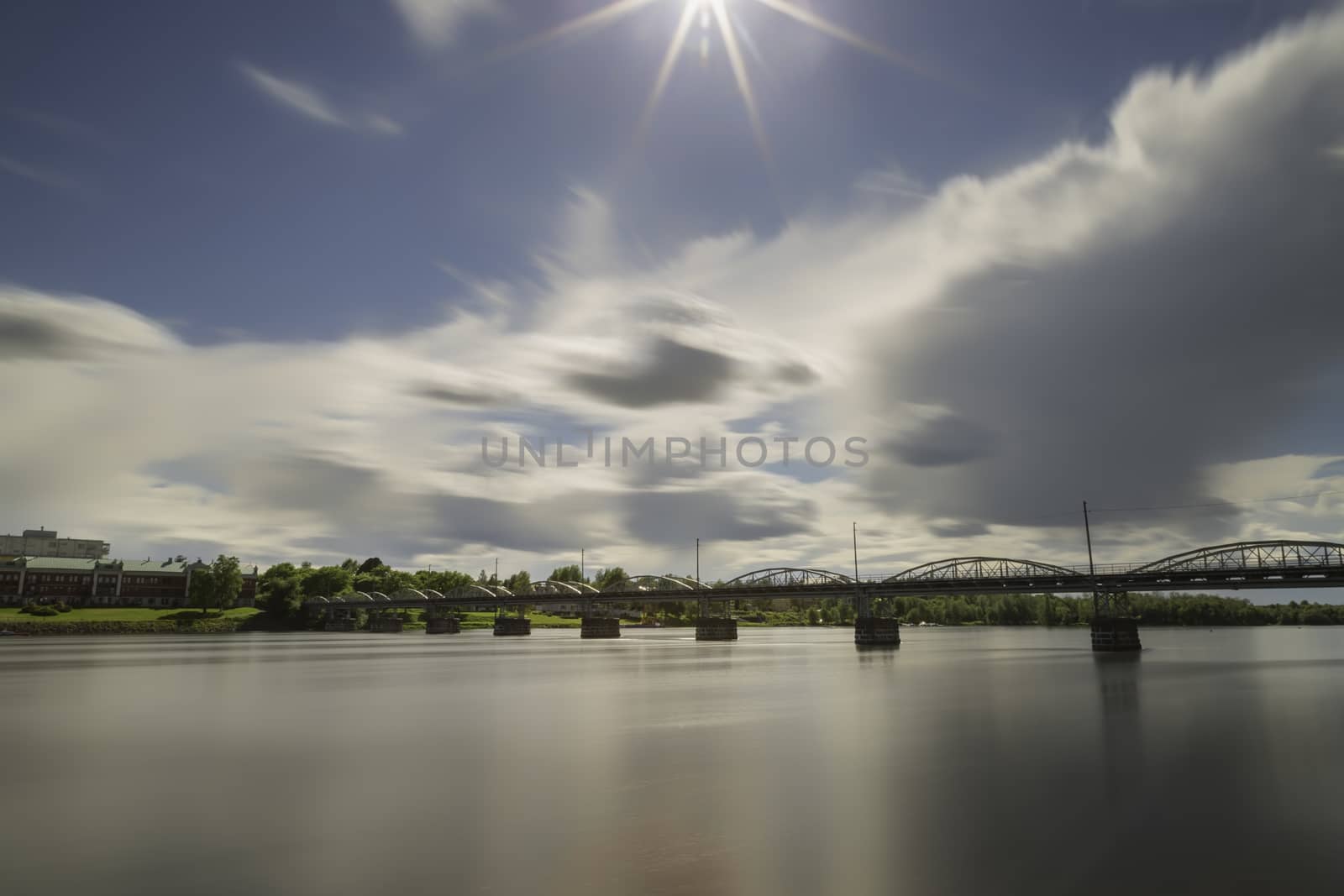 Bride over River in Umea, Sweden with a partly cloudy sky.