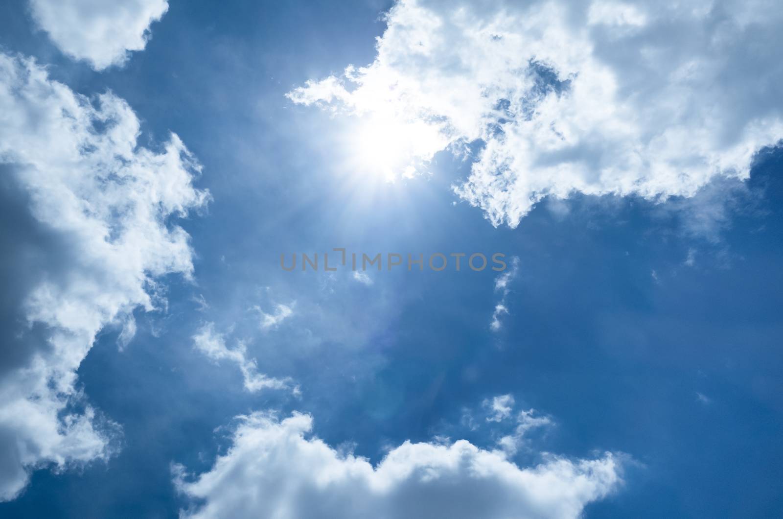 Sun on blue sky with tiny cloud .