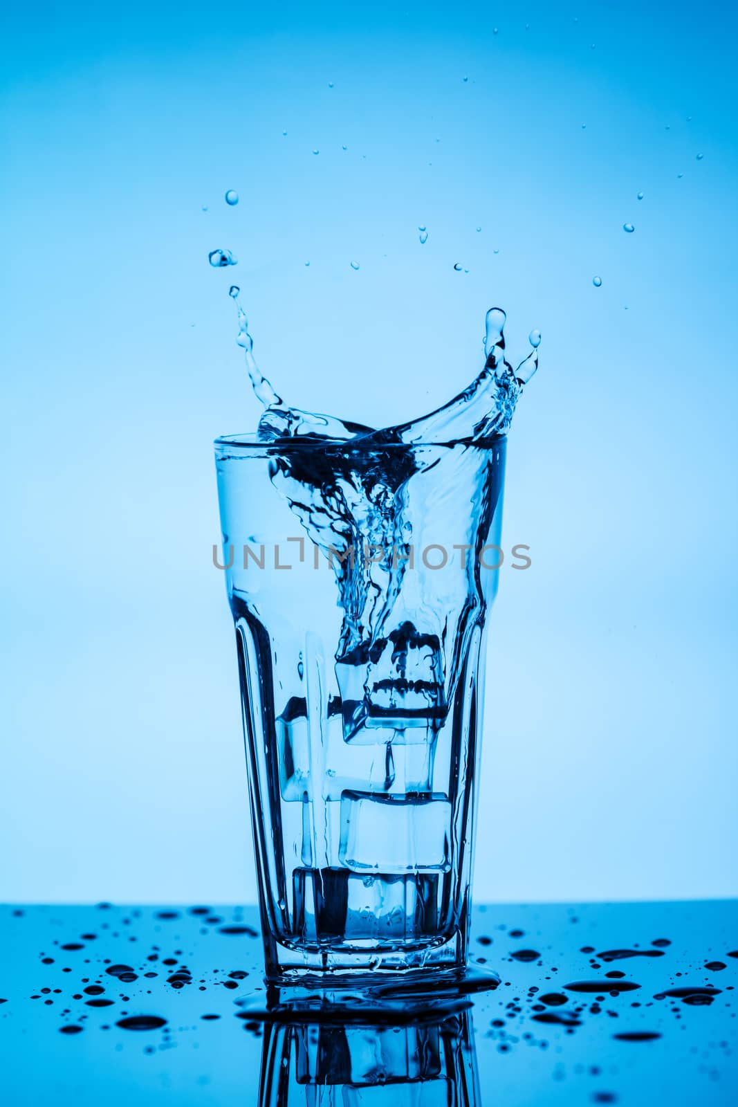 Splashing water from a glass with ice cubes