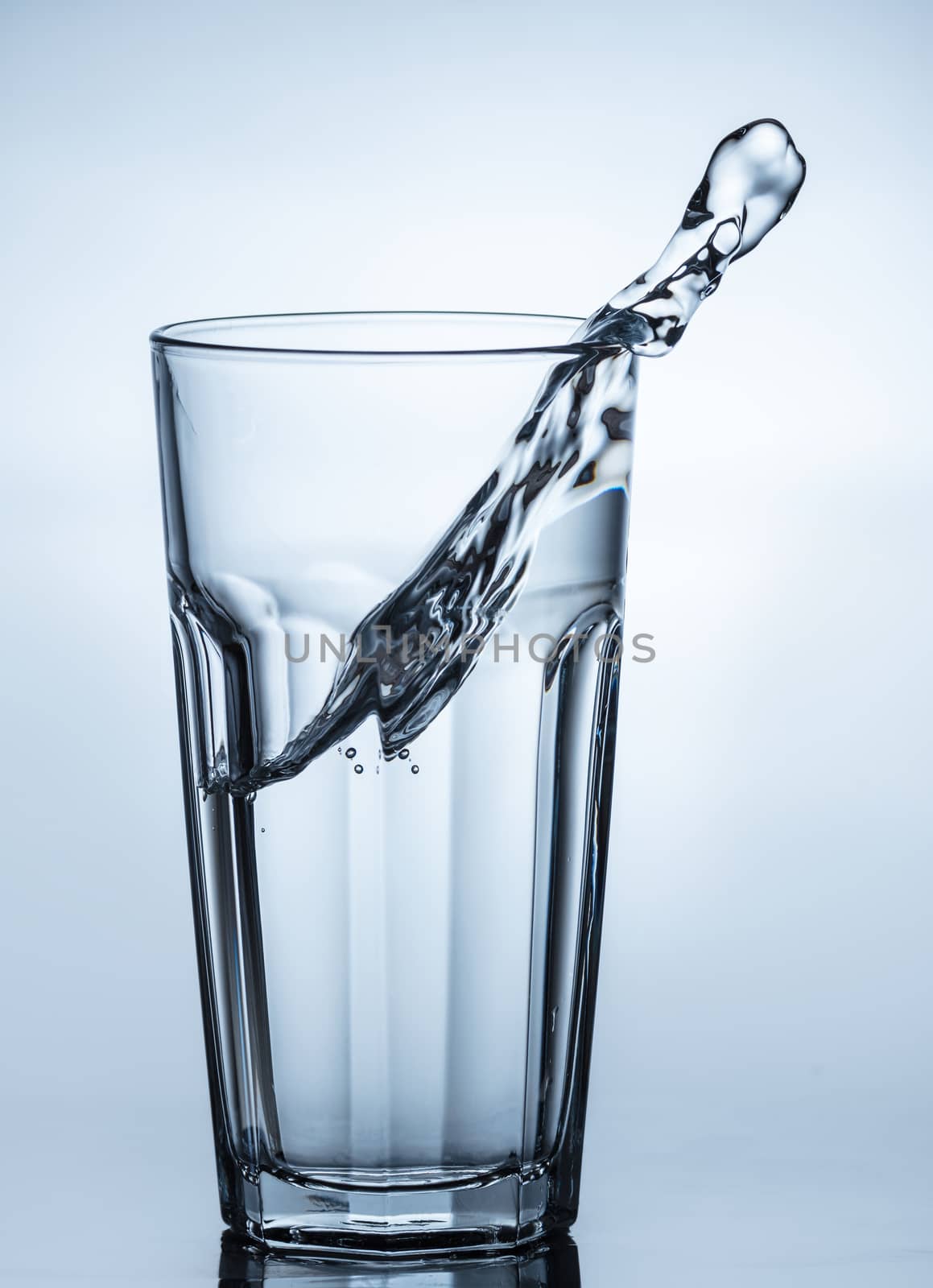 water splashing out of a glass with reflection