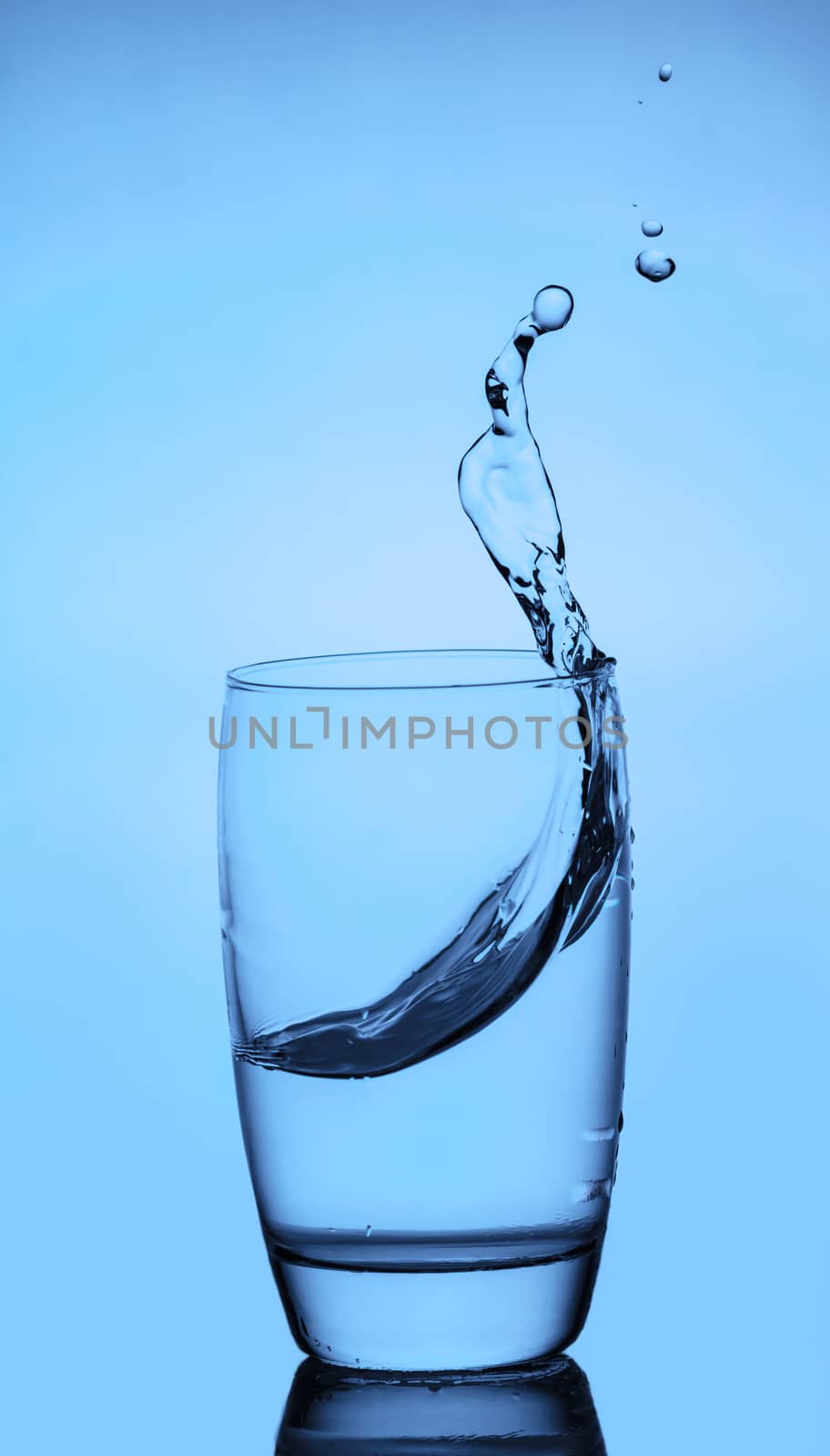 water splashing out of a glass with reflection