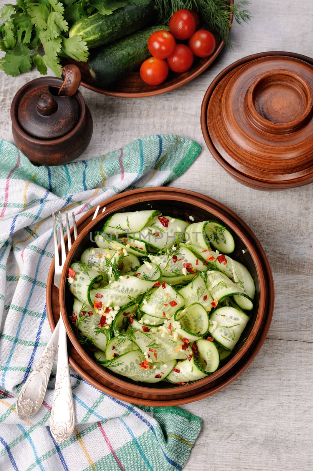 A bowl of salad from cucumber strips with spices, garlic and dill. Rustic style.