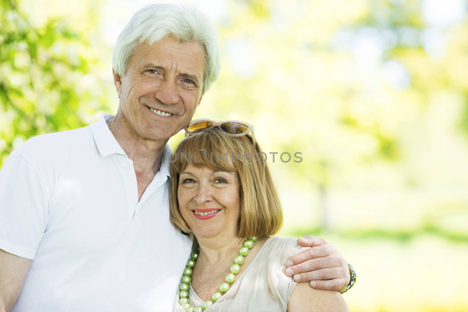 Happy senior couple hug in summer park