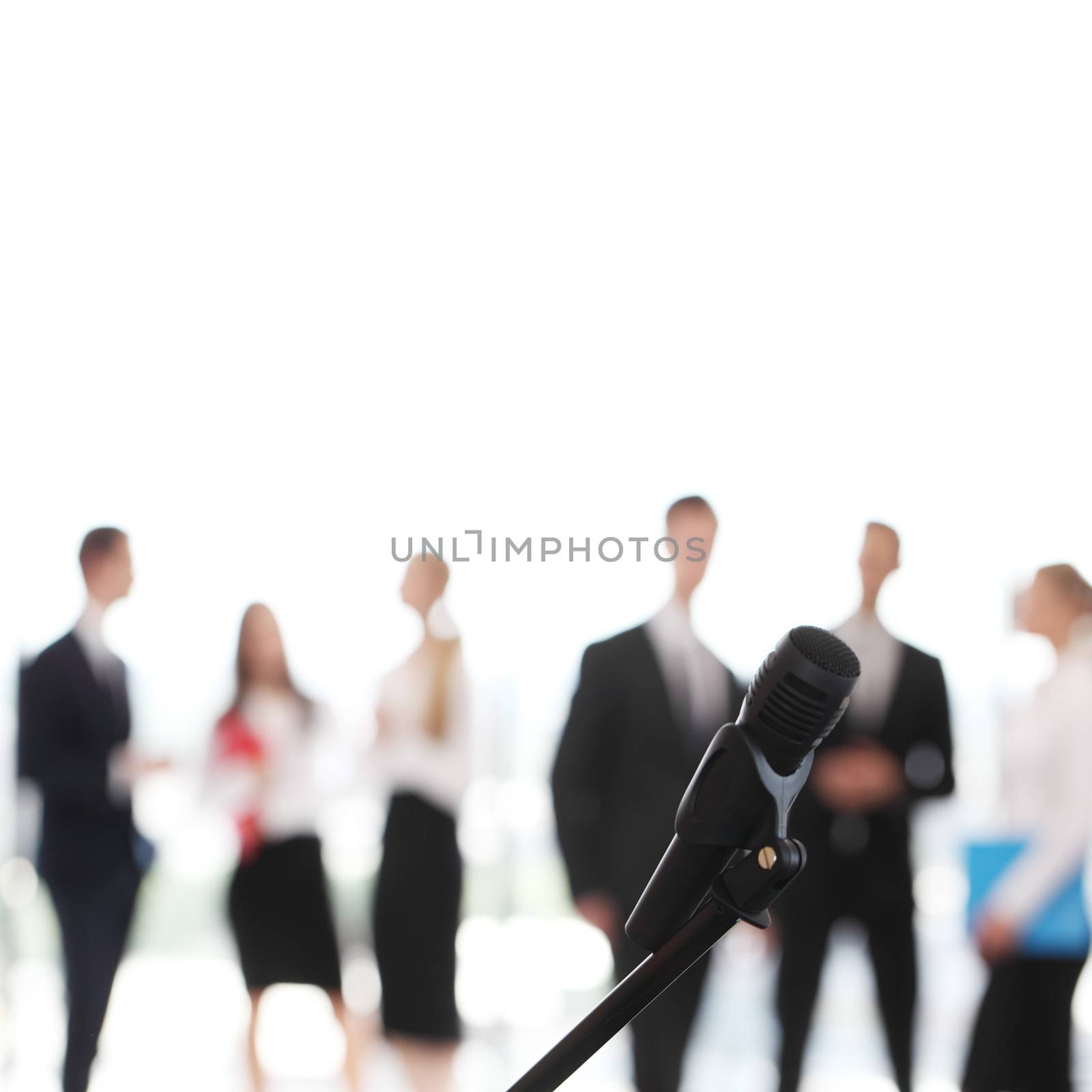 Business people at conference in meeting room, focus on microphone