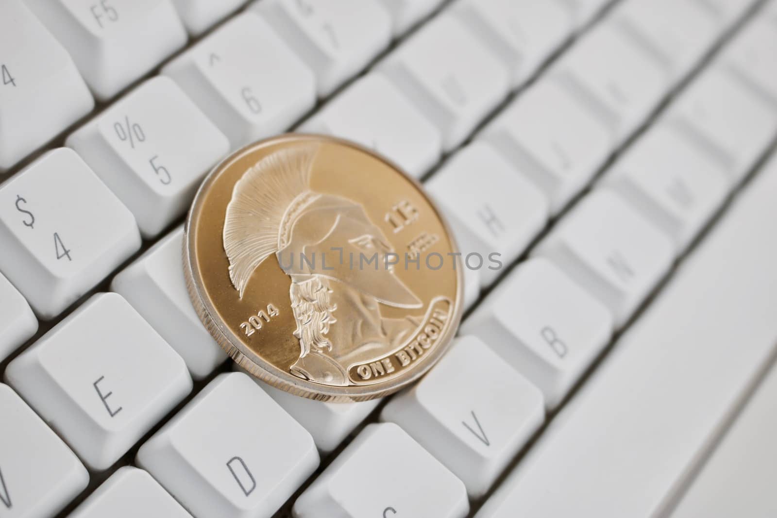 Digital currency physical gold titan bitcoin on white computer keyboard.