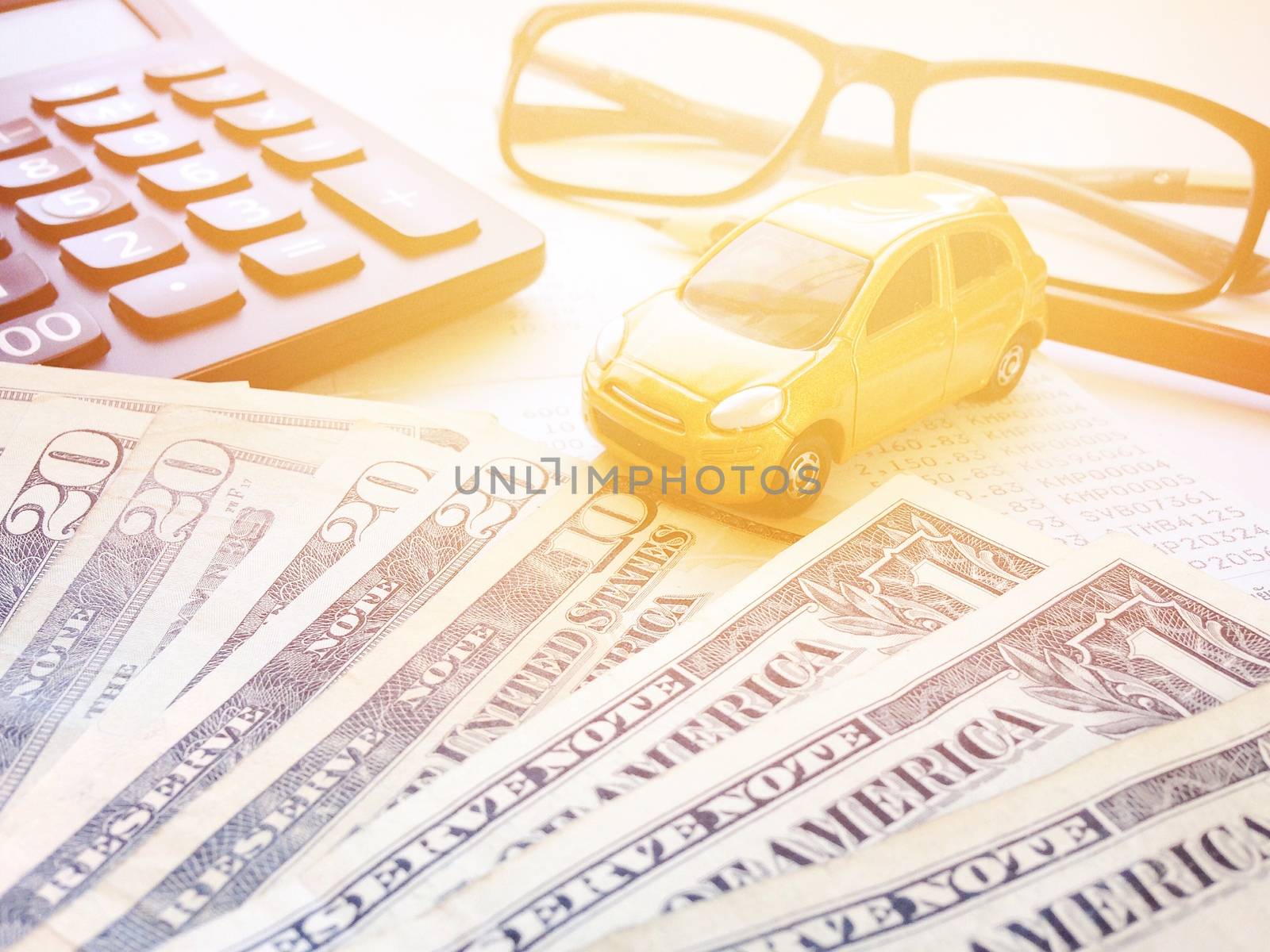 Business, finance, savings, banking or car loan concept : Miniature car model, pencil, calculator, eyeglasses, money and savings account passbook or financial statement on white background