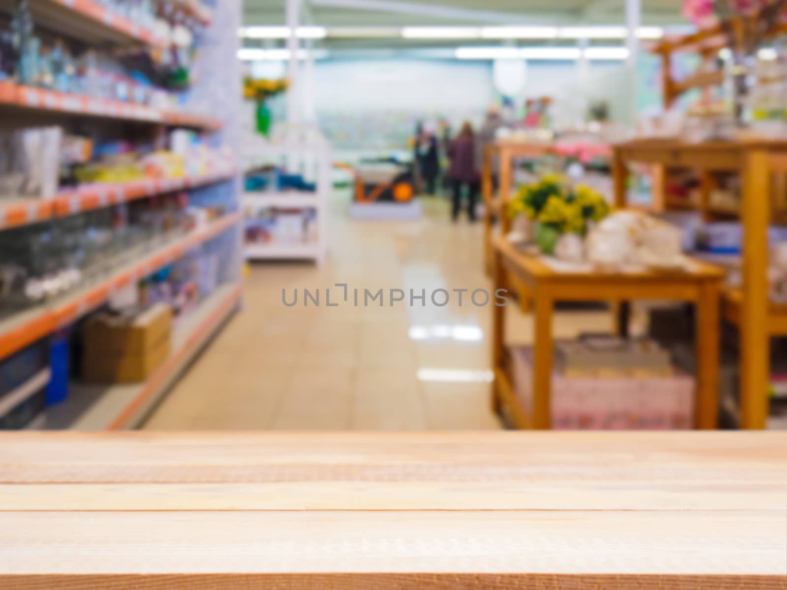 Light wooden empty table in front of blurred DIY supermarket background. Mock up for display of product.