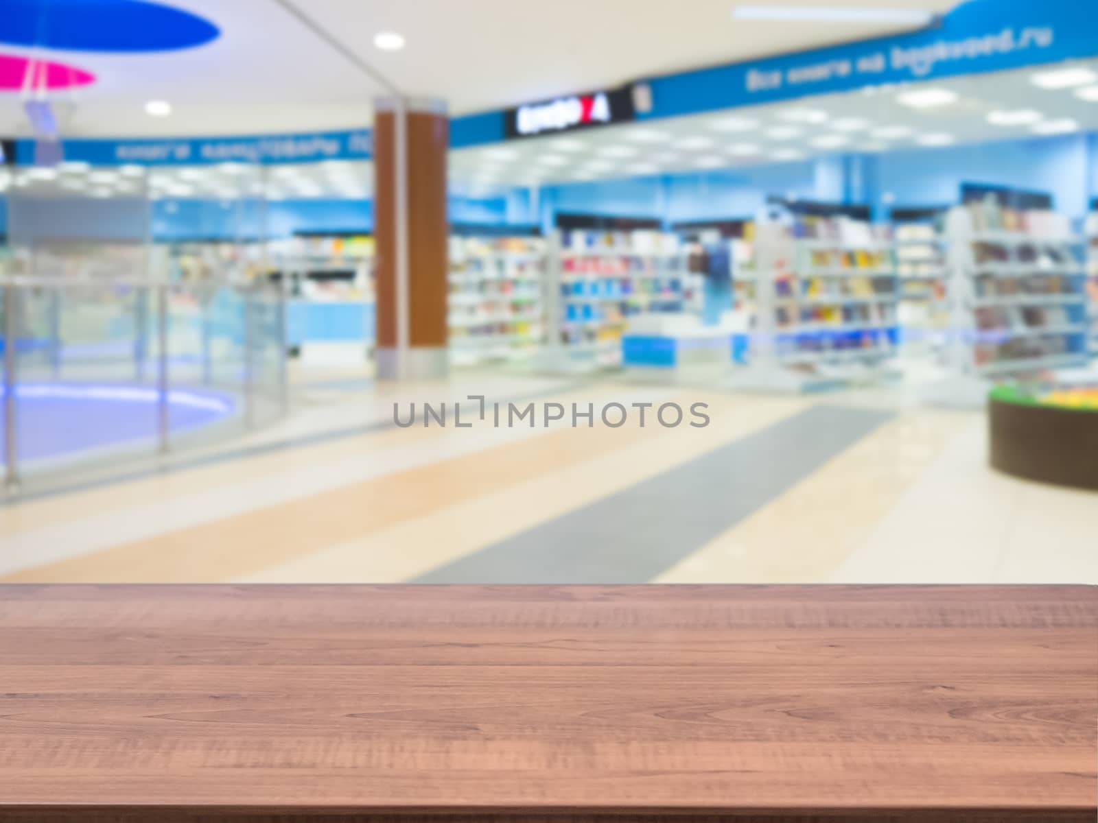 Brown wooden board empty table in front of blurred shopping mall - can be used for display or montage your products. Mockup for display of product.