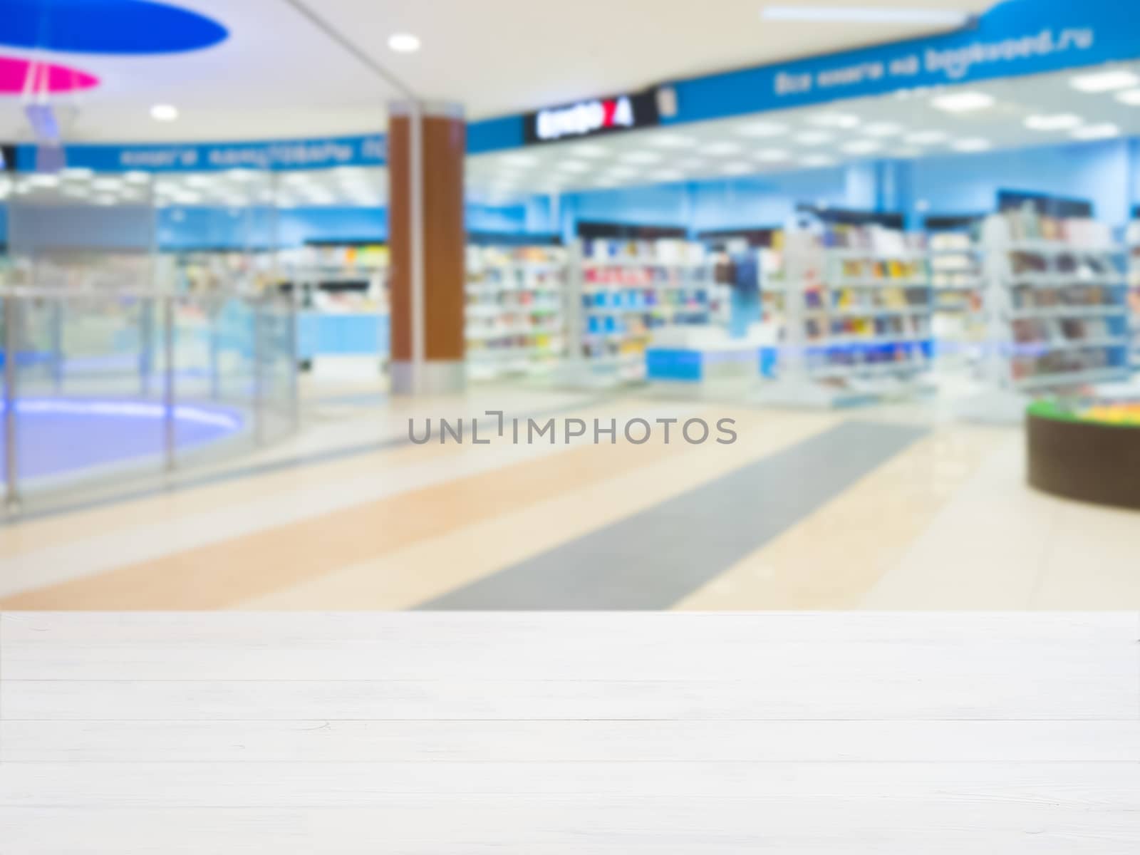 White wooden board empty table in front of blurred shopping mall - can be used for display or montage your products. Mockup for display of product.